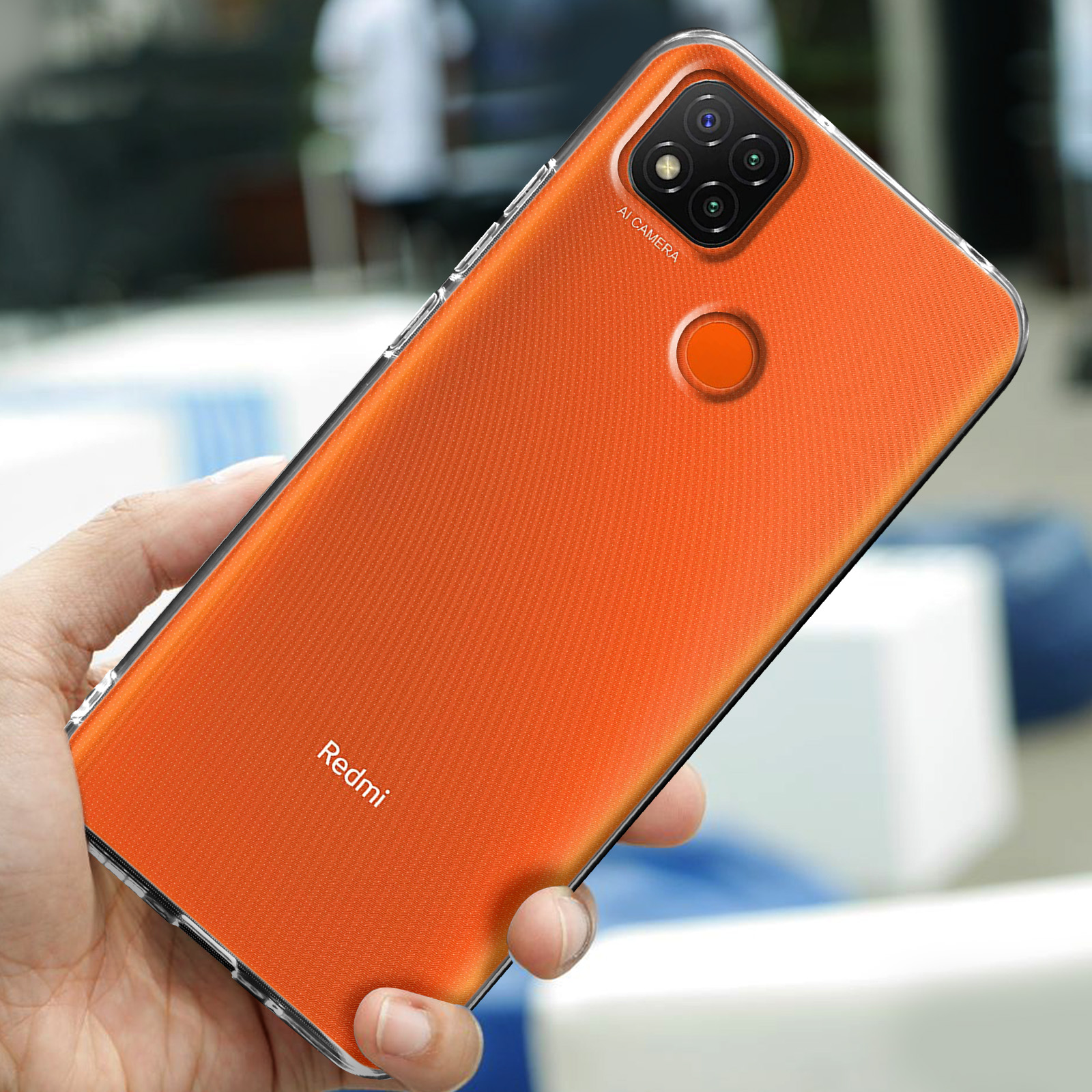 Une main tient un smartphone orange avec trois caméras et un flash.