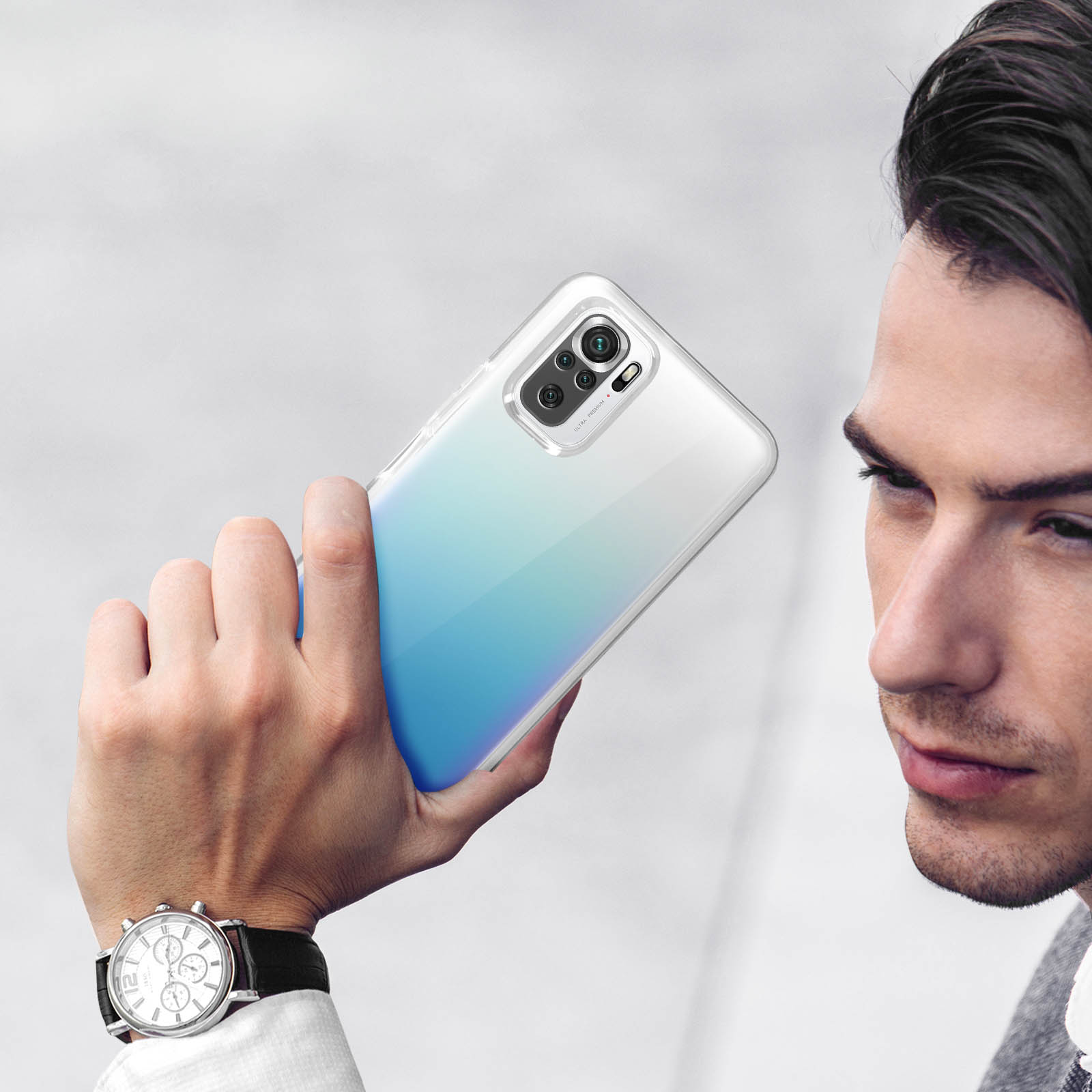 Uomo che tiene un telefono trasparente con sfumatura blu e quattro fotocamere.