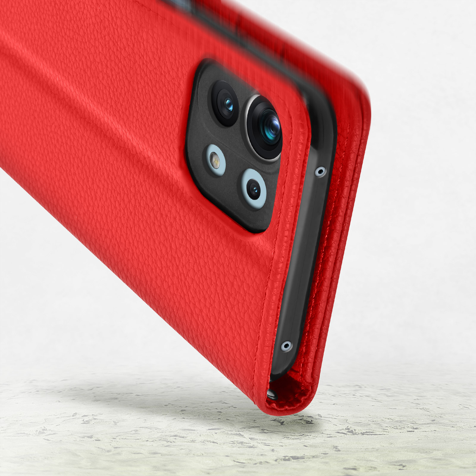 Custodia rossa in pelle per telefono con ritaglio fotocamera, su superficie in pietra.