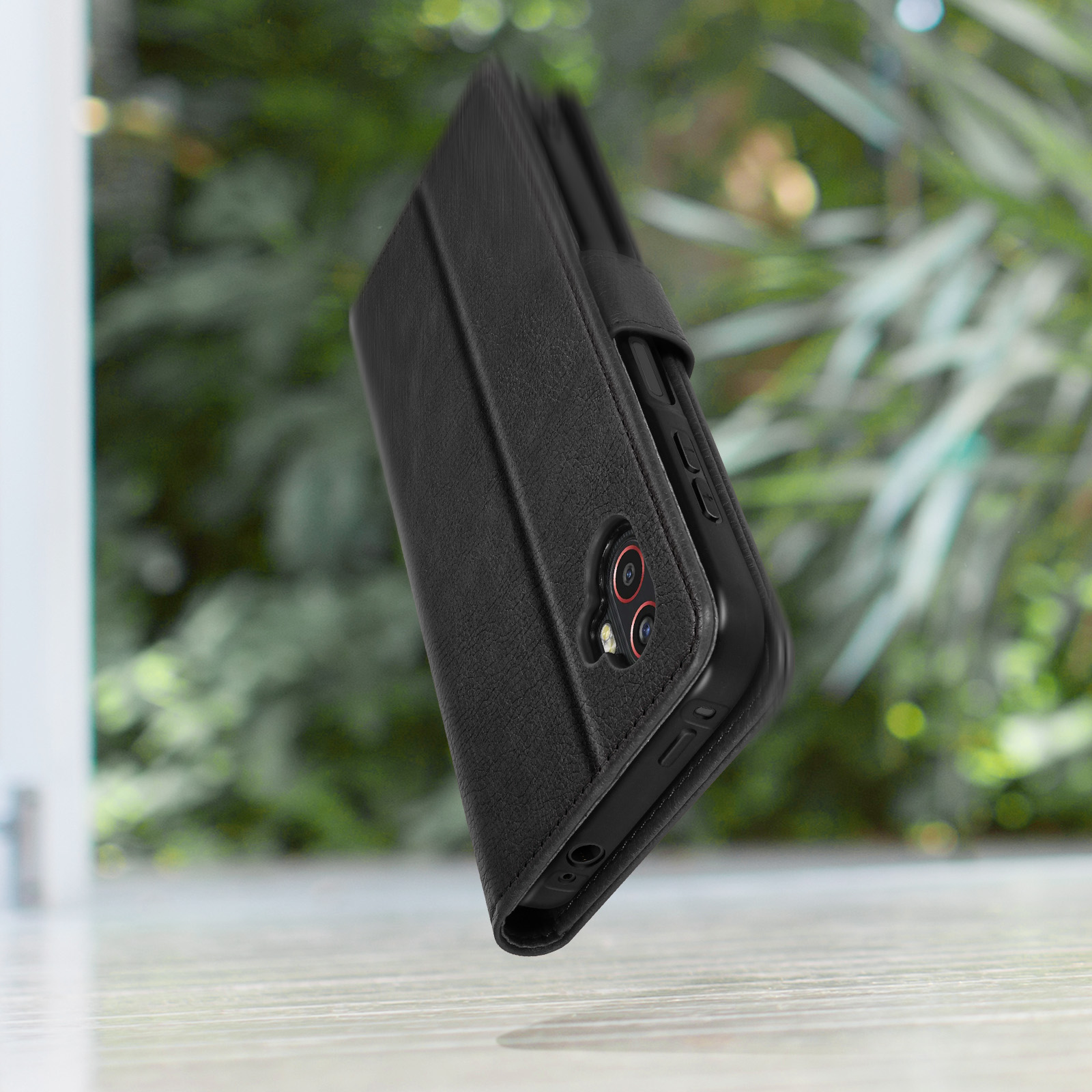Zwarte leren flipcase voor smartphone buitenshuis.