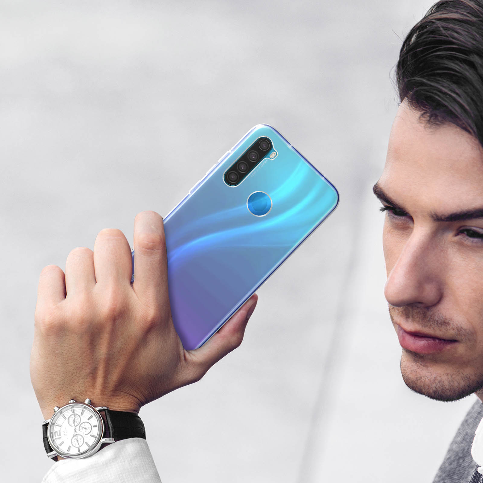 Een man houdt een blauw-paarse smartphone met vier camera's vast.