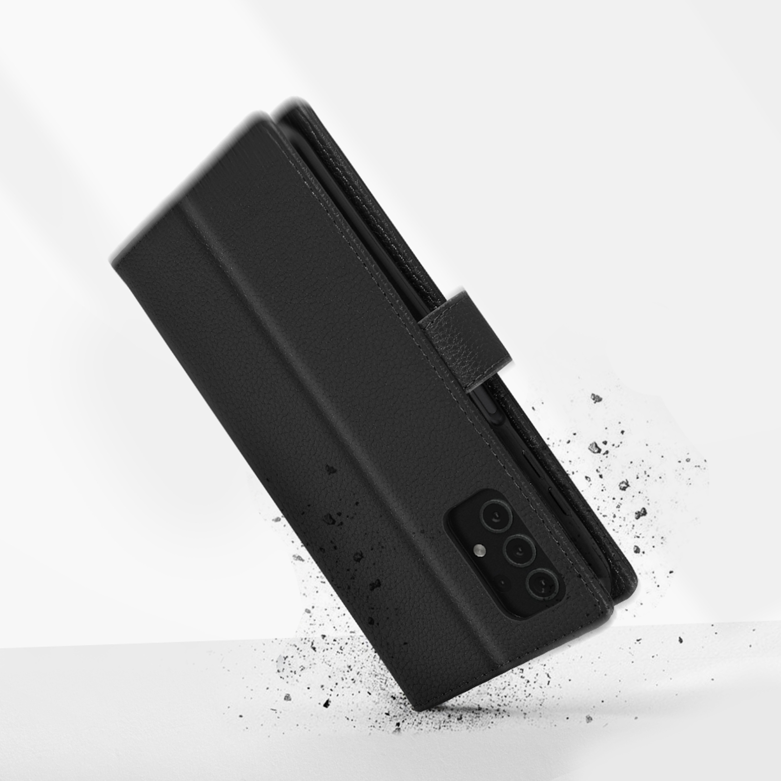 Custodia a libro nera per telefono con ritaglio fotocamera che cade su polvere grigia.