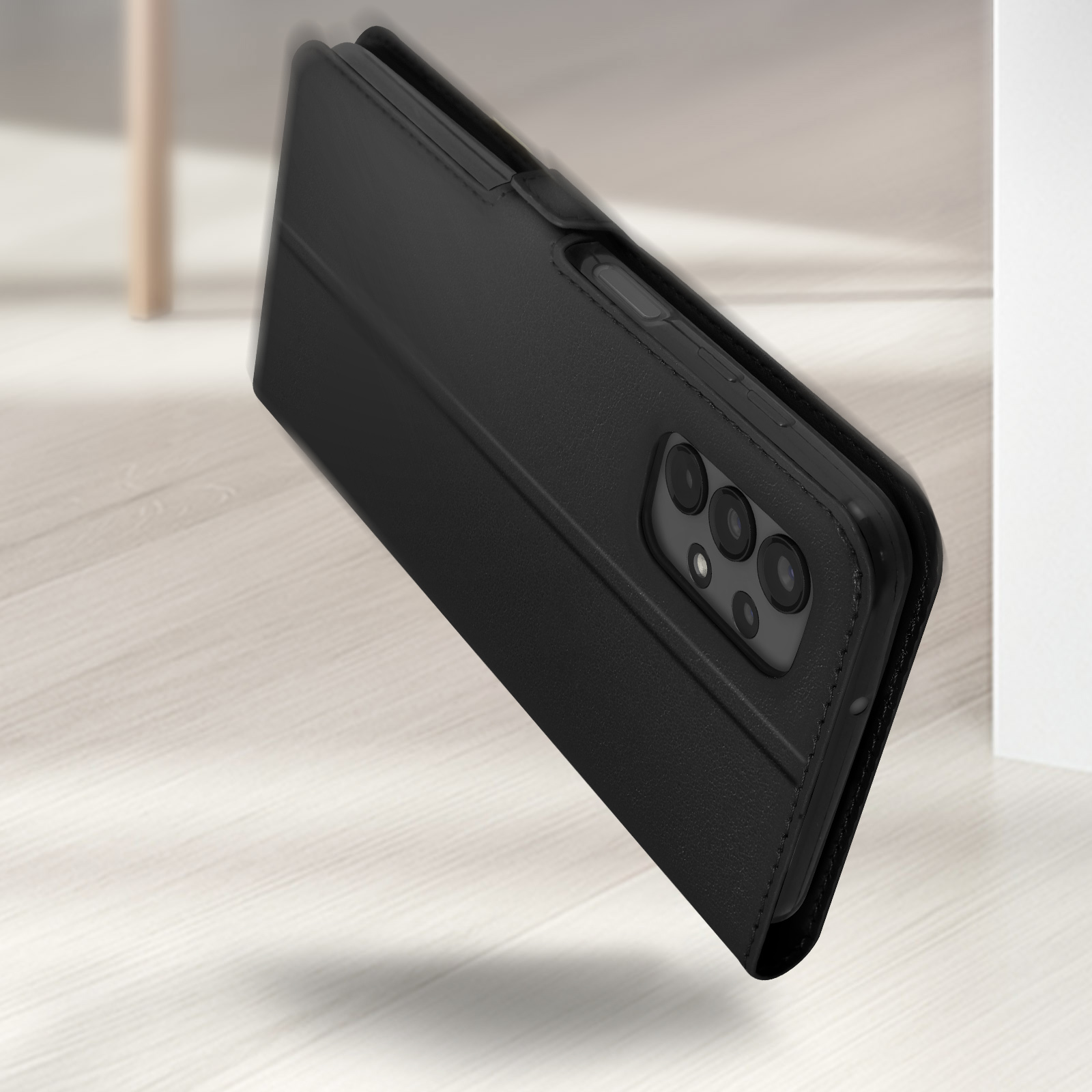 Téléphone noir avec appareil photo sur le côté sur un plancher en bois clair.