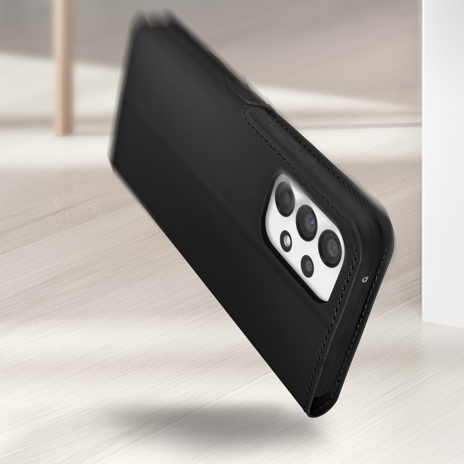 Étui noir en cuir pour téléphone avec quatre caméras sur un parquet clair
