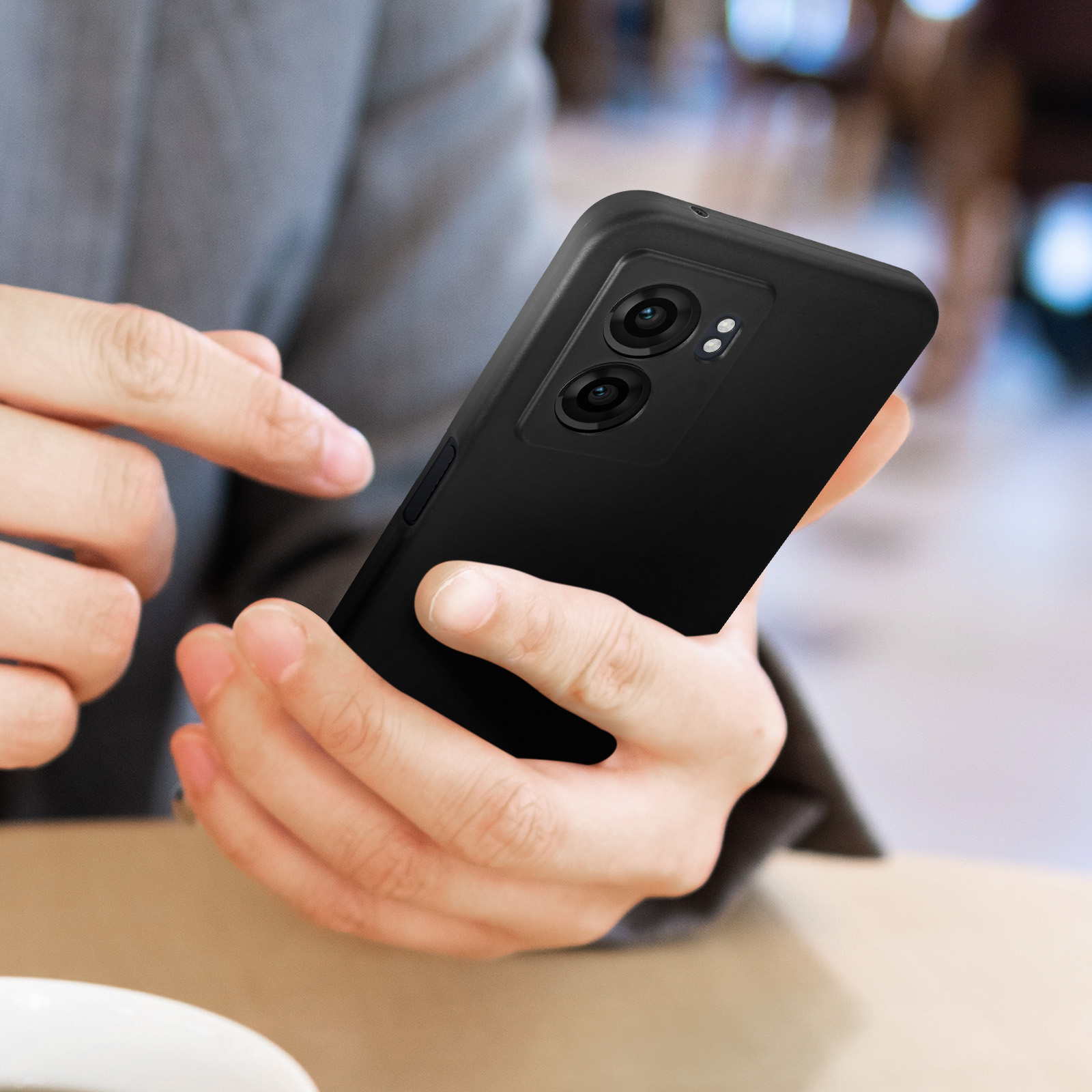 Persona che tiene uno smartphone nero con due fotocamere.