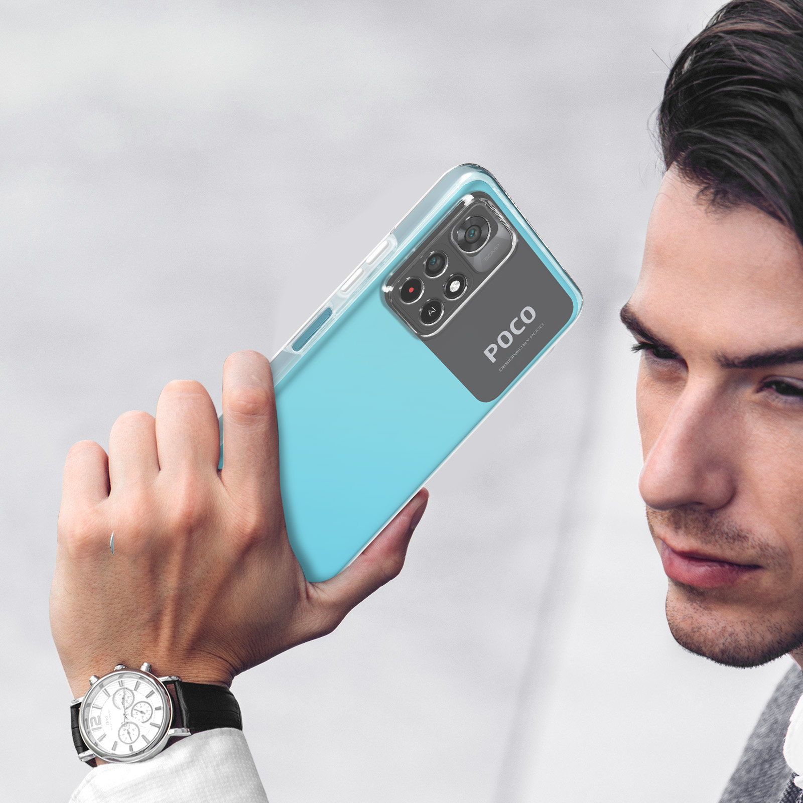 Homme tenant un téléphone bleu dans une coque transparente. Gros plan sur les caméras.