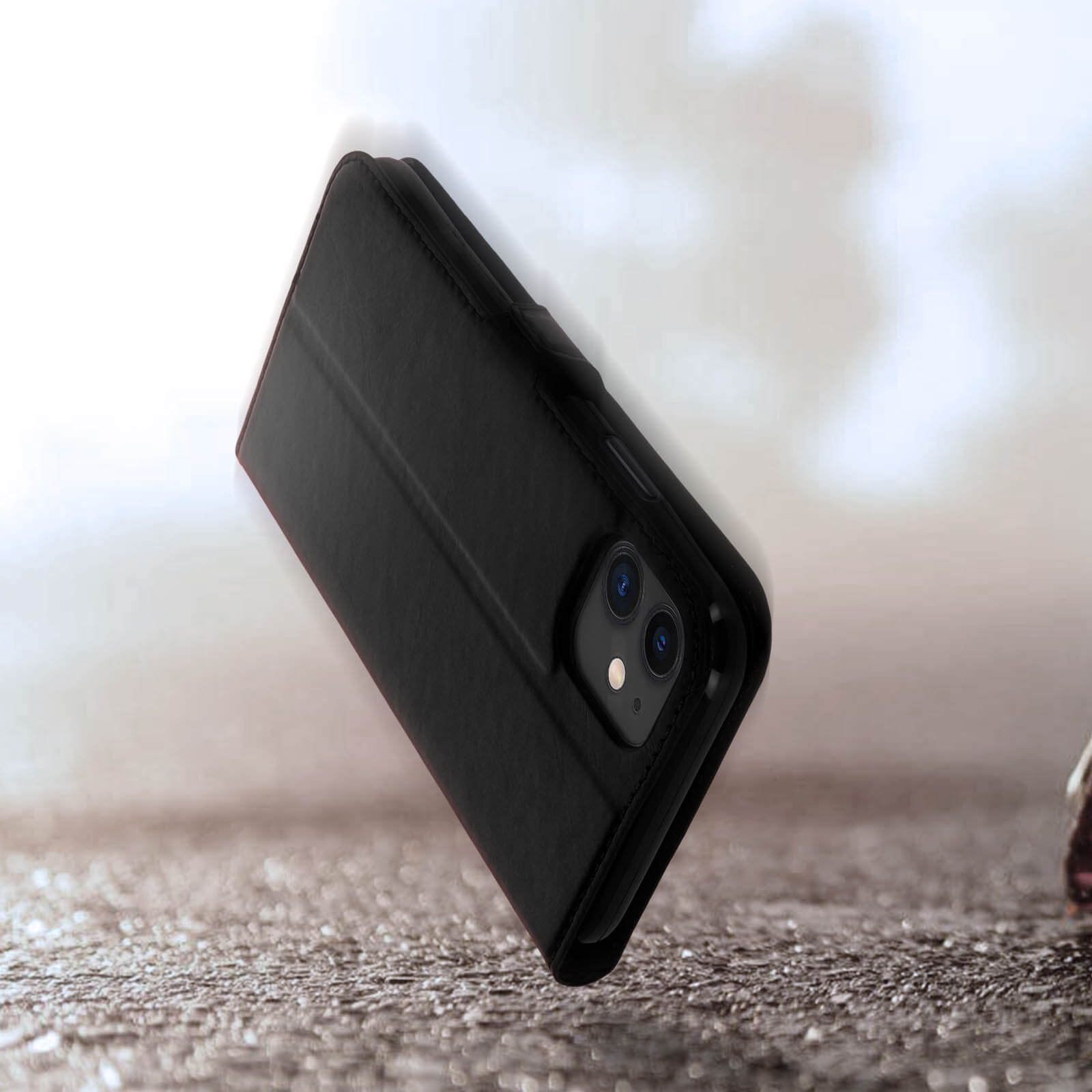 Zwarte flip telefoonhoes met zichtbare camera op een ruw oppervlak.