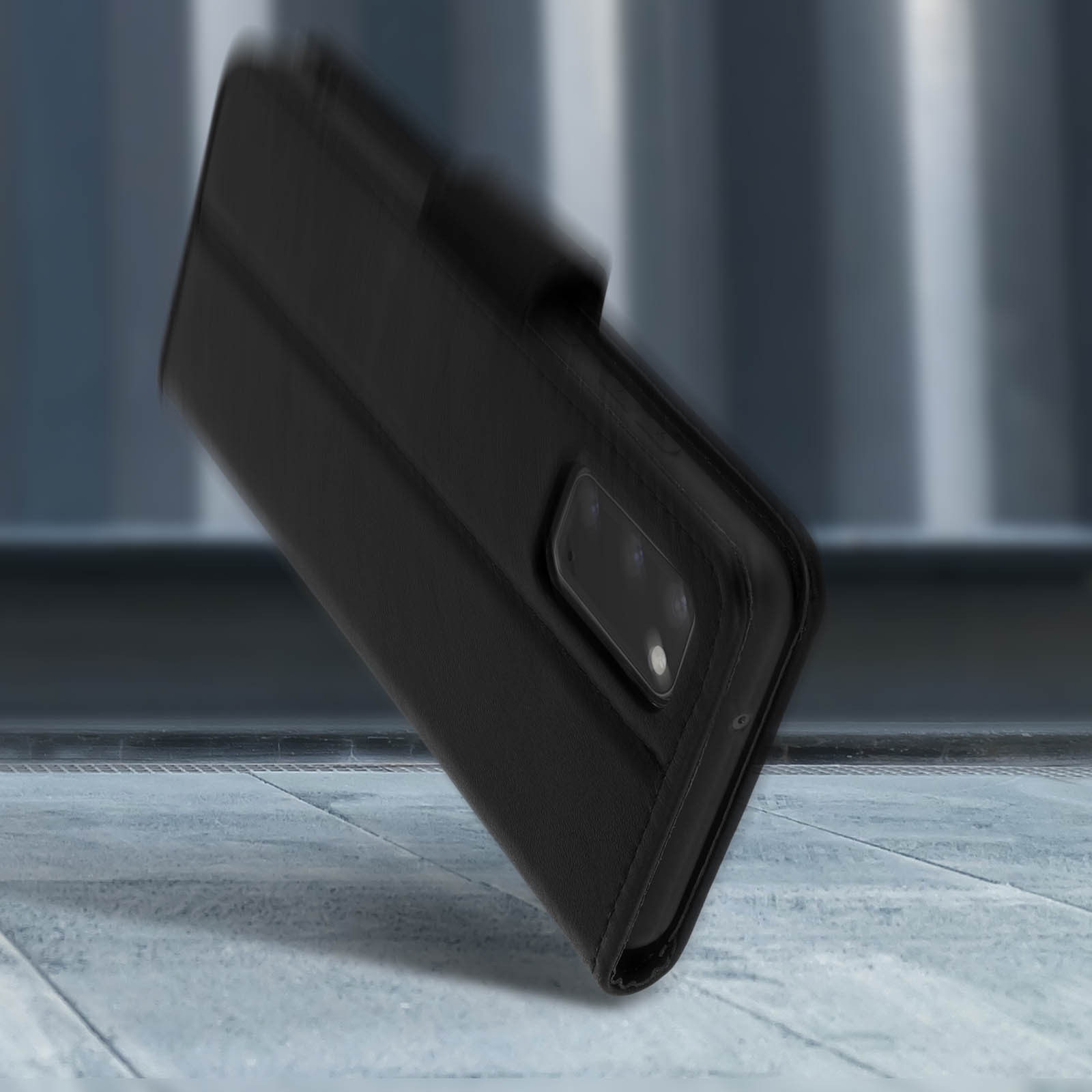 Custodia per telefono nera a libro su pavimento grigio con sfondo sfocato.