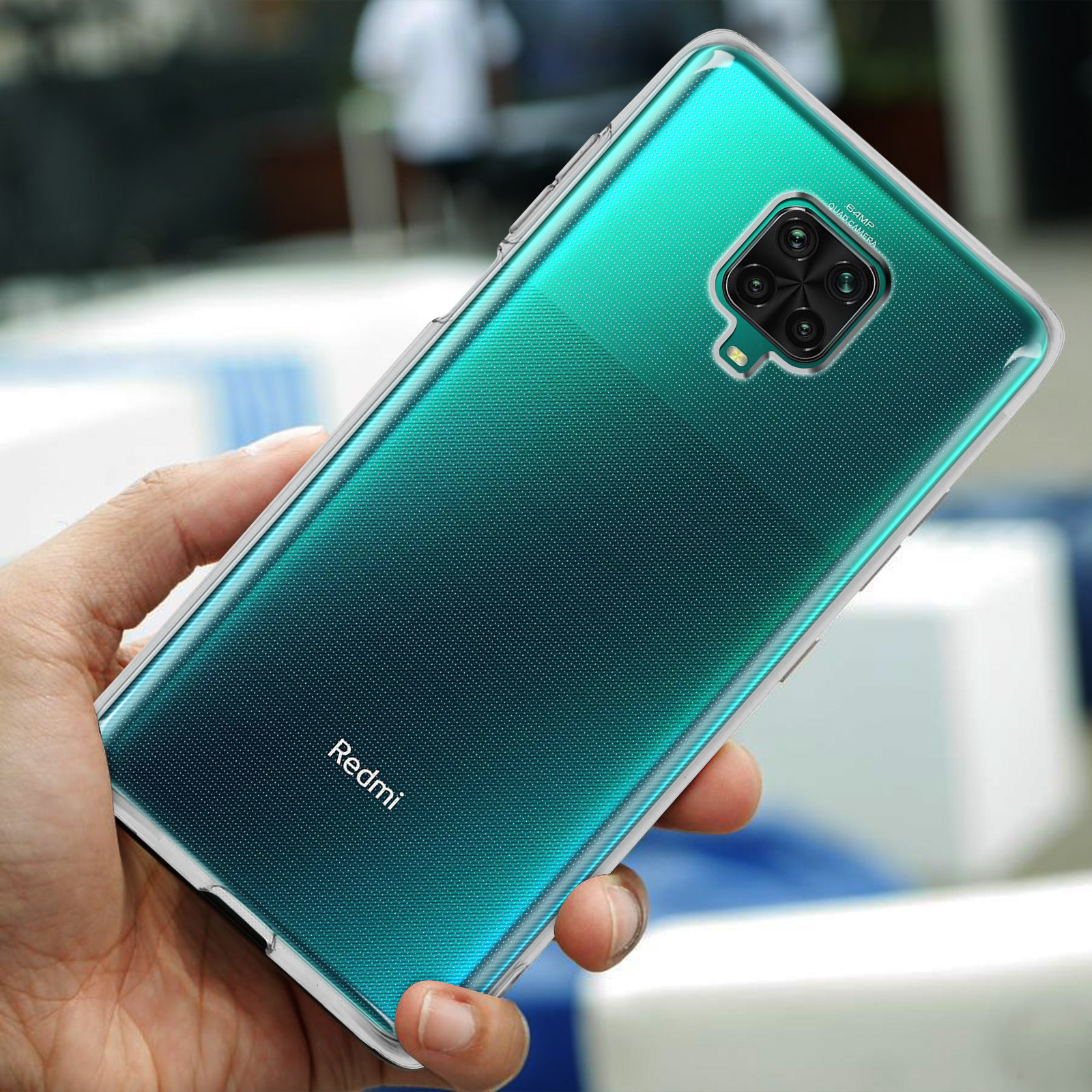 Une main tient un smartphone turquoise avec un quadruple appareil photo au dos.