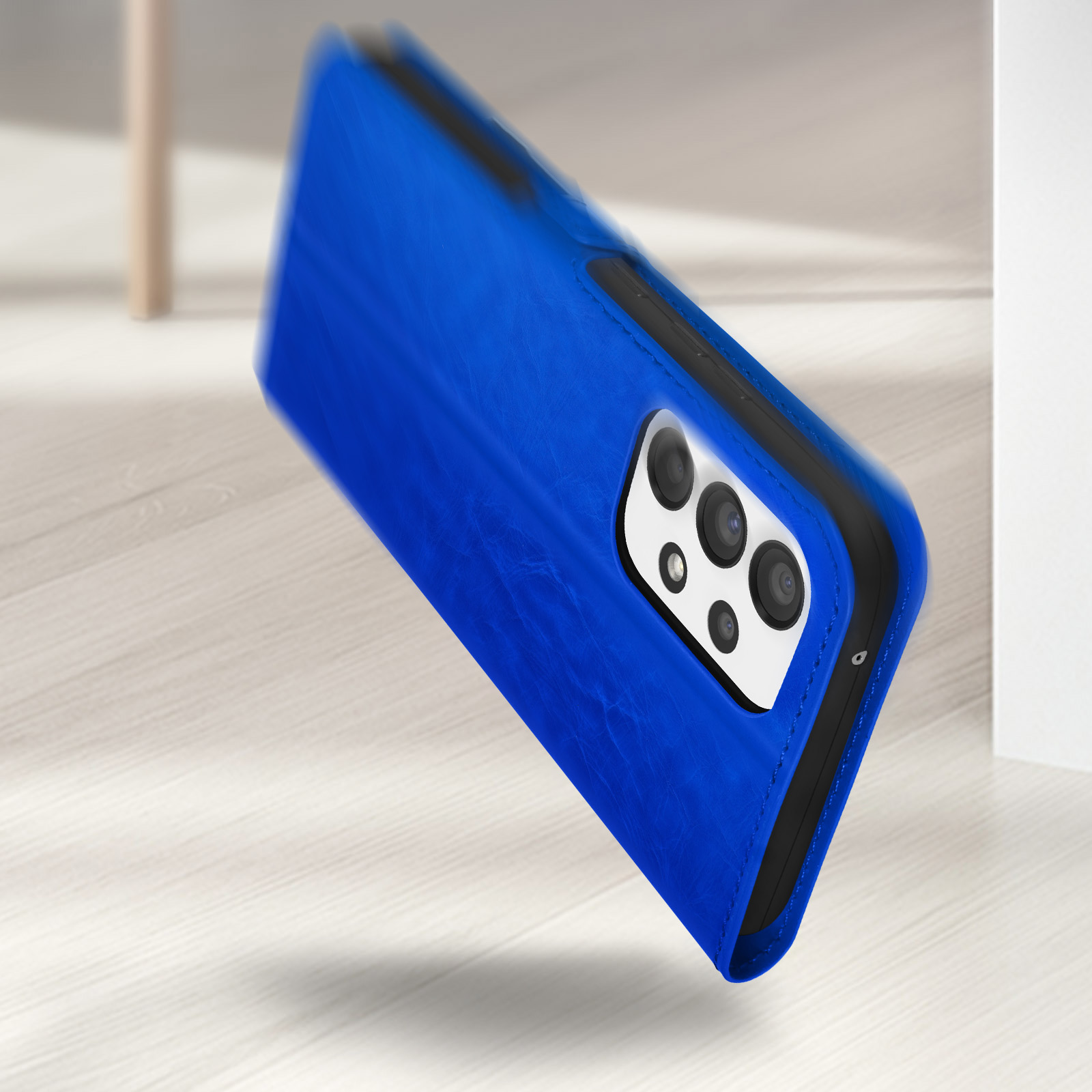 Un étui à rabat bleu pour téléphone est sur un sol en bois.
