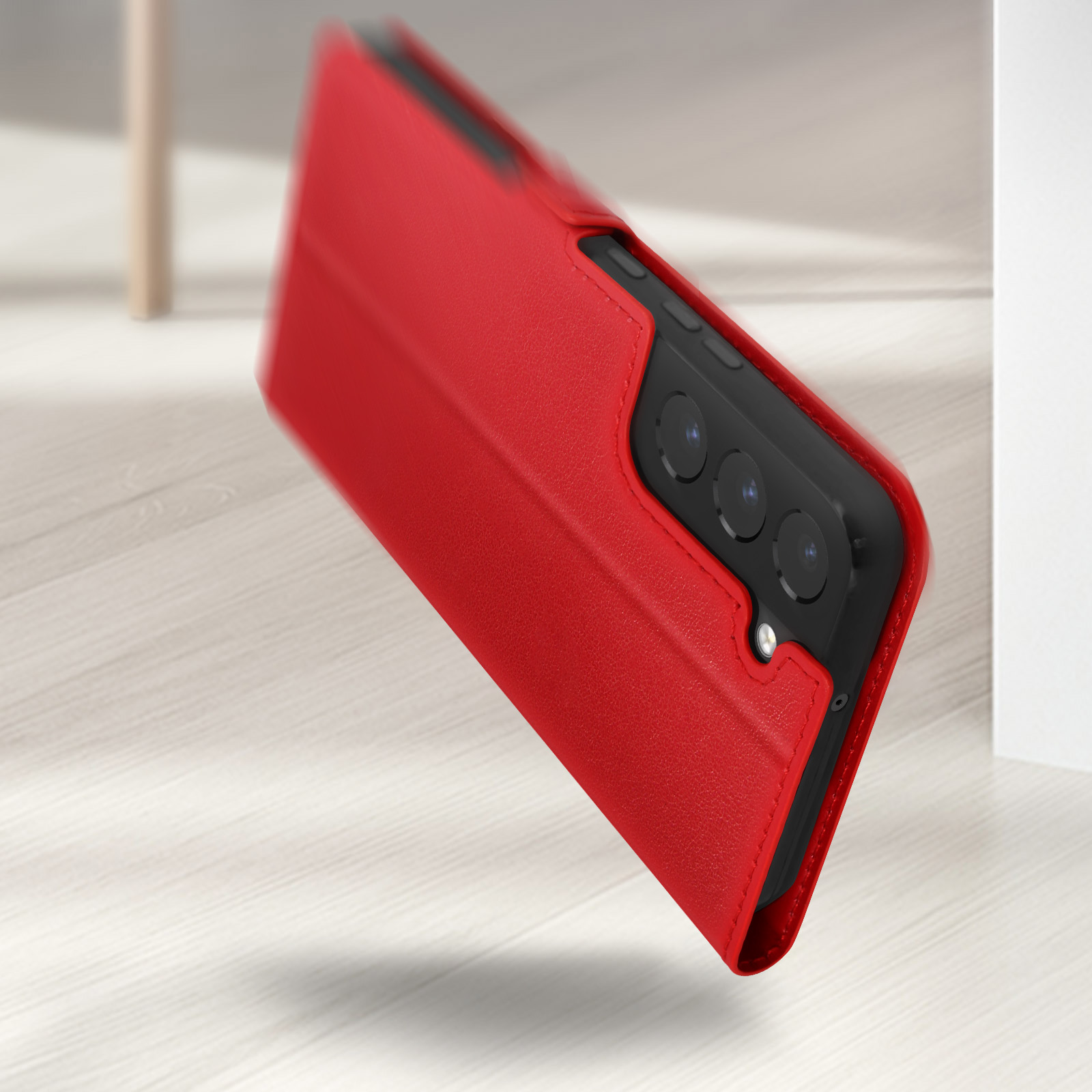 Étui de téléphone rouge avec trois modules caméra sur un plancher en bois.