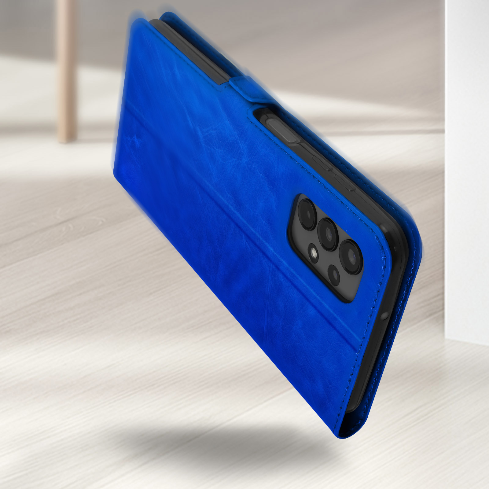 Étui bleu en cuir pour téléphone avec trois caméras sur un sol en bois.