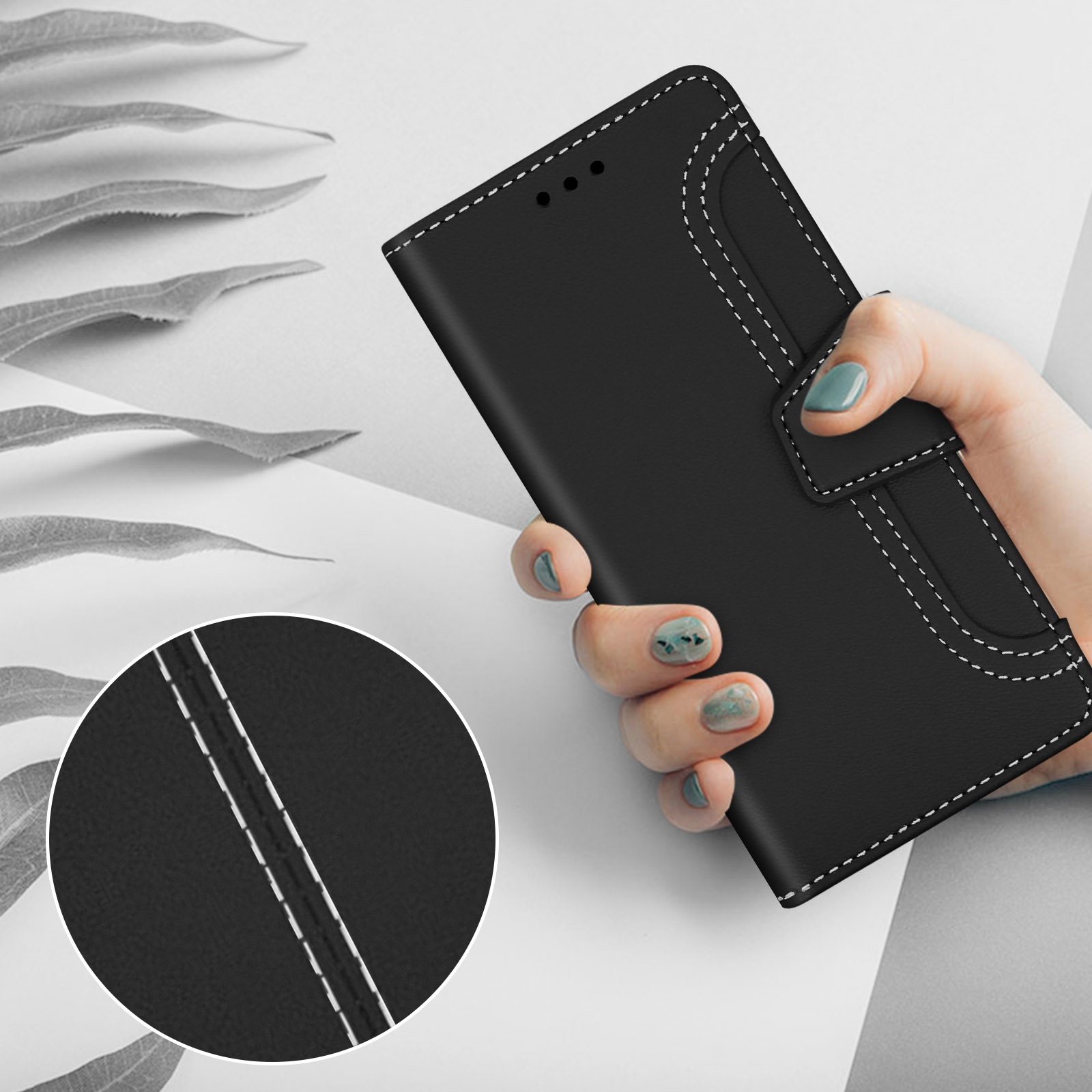 Zwart telefoonhoesje met witte stiksels, vastgehouden door een hand met blauwgroene nagels.