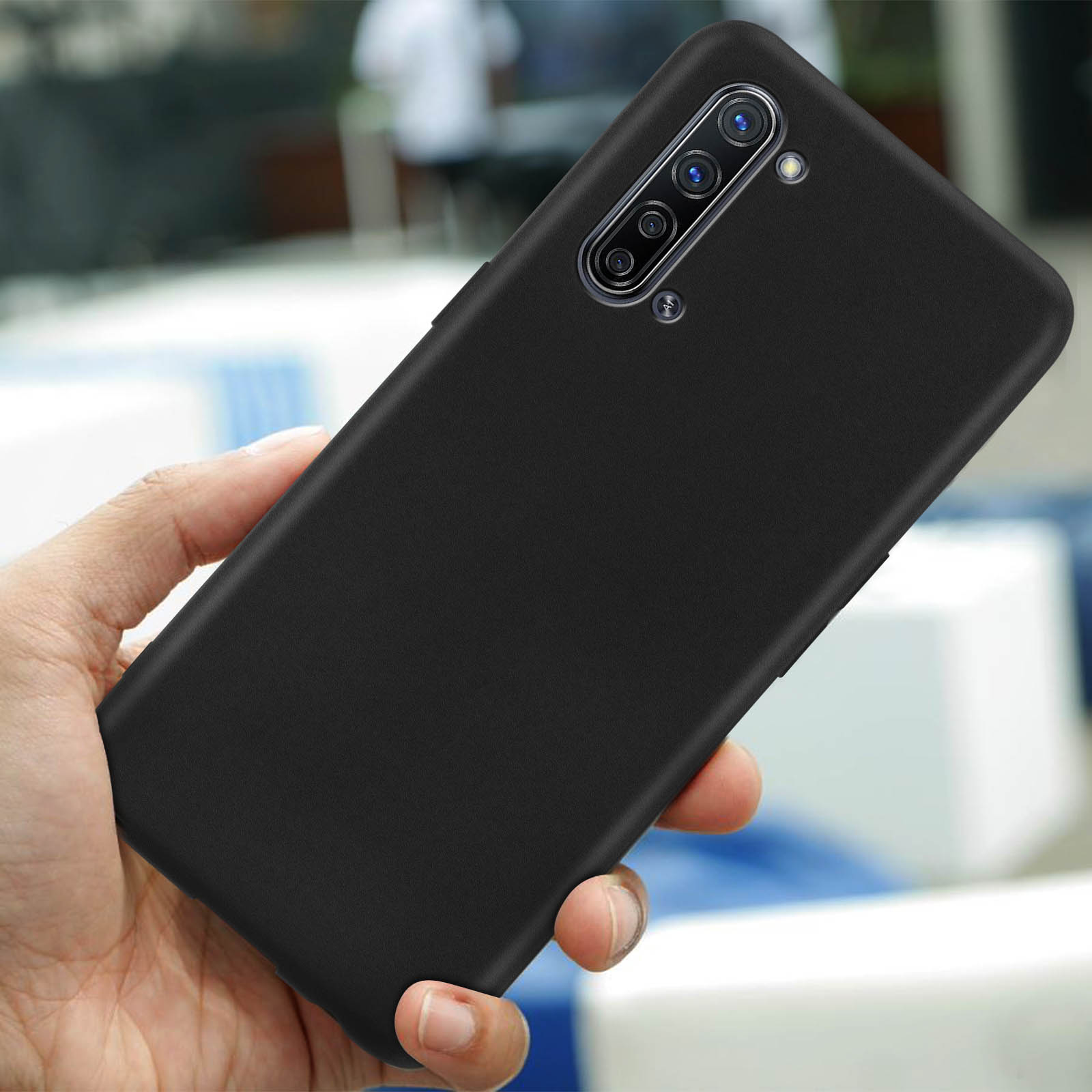 Coque de téléphone noire avec trois caméras, tenue dans une main.