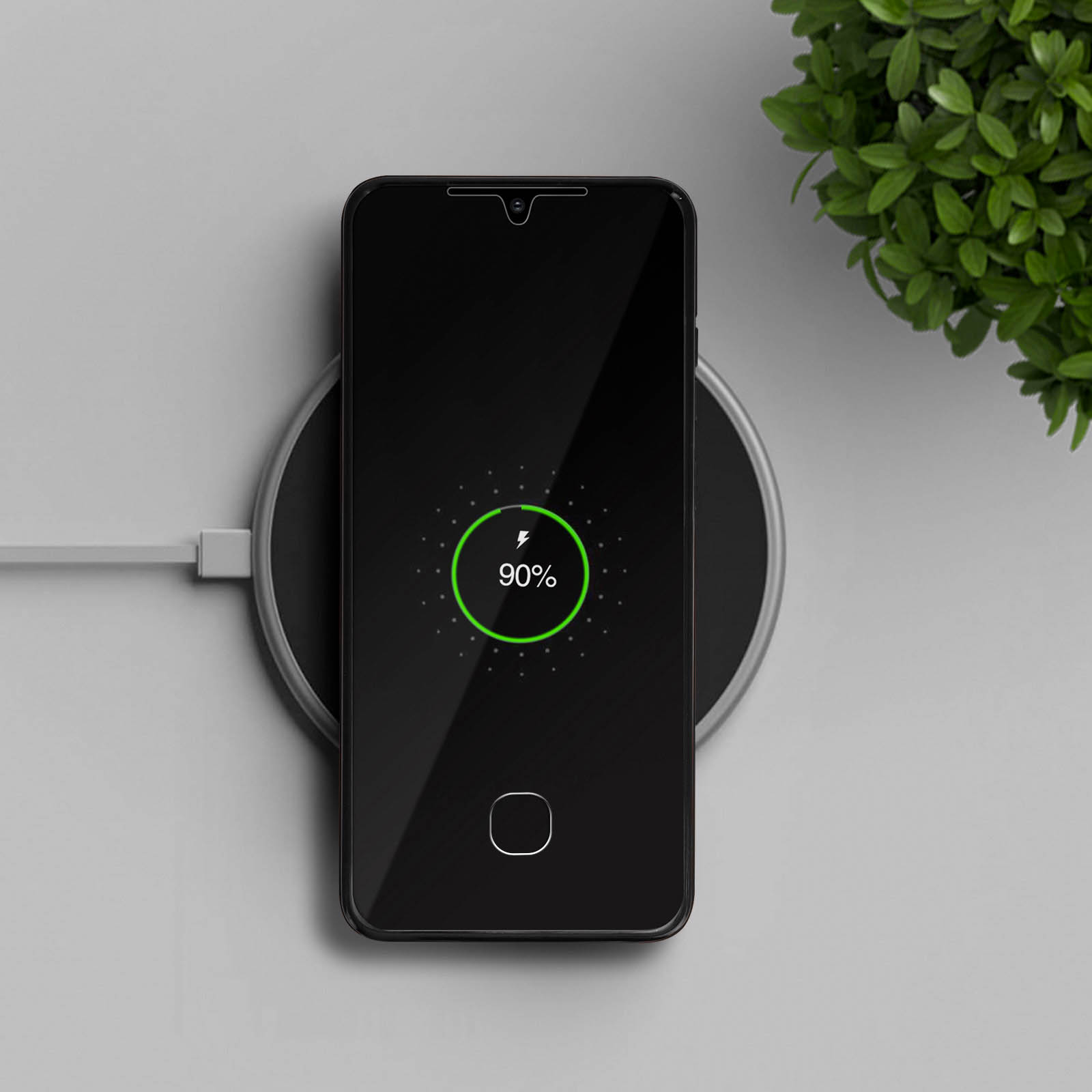 Een smartphone laadt op een ronde oplaadpad, met 90% batterij.