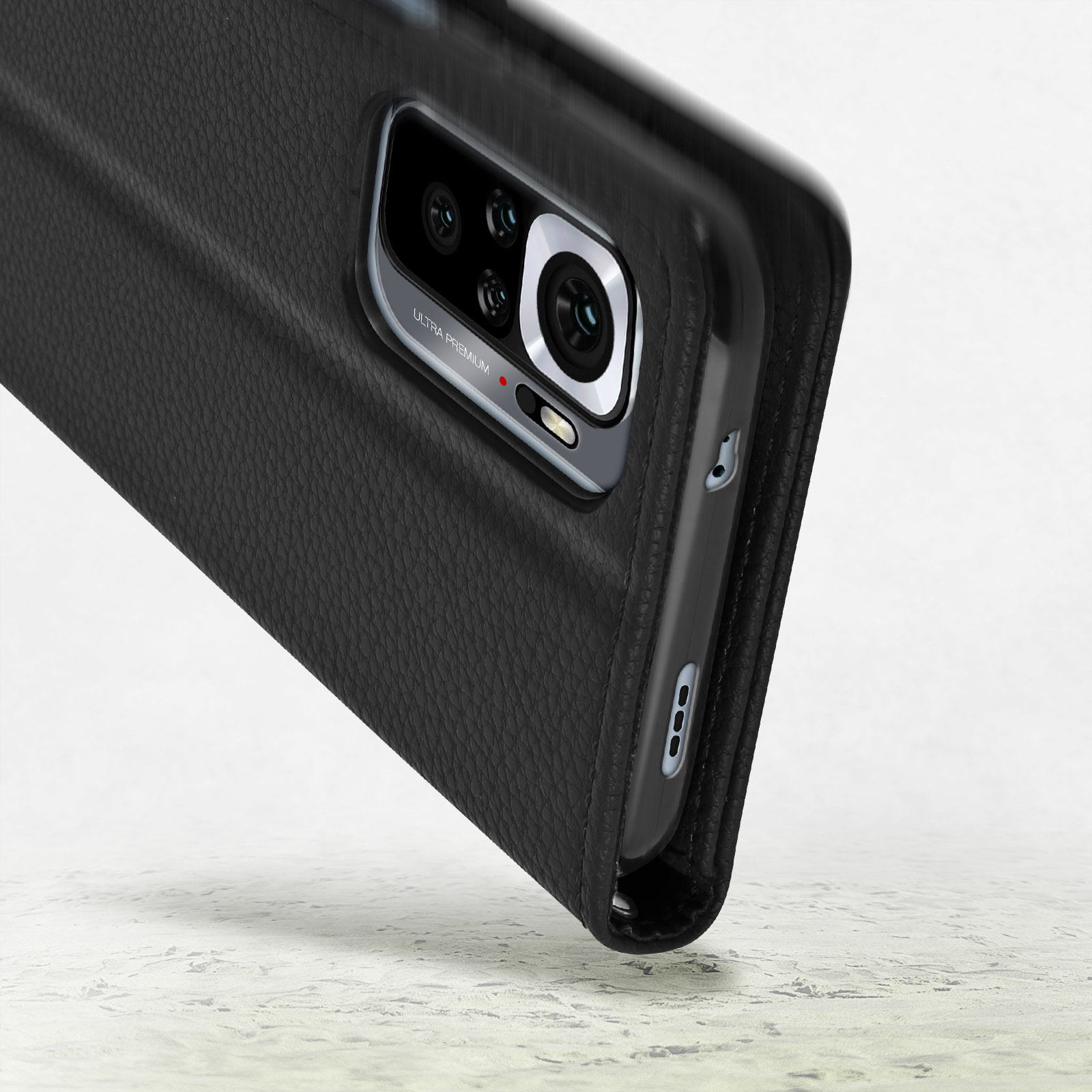Telefono cellulare nero con custodia in pelle e modulo fotocamera su sfondo chiaro.