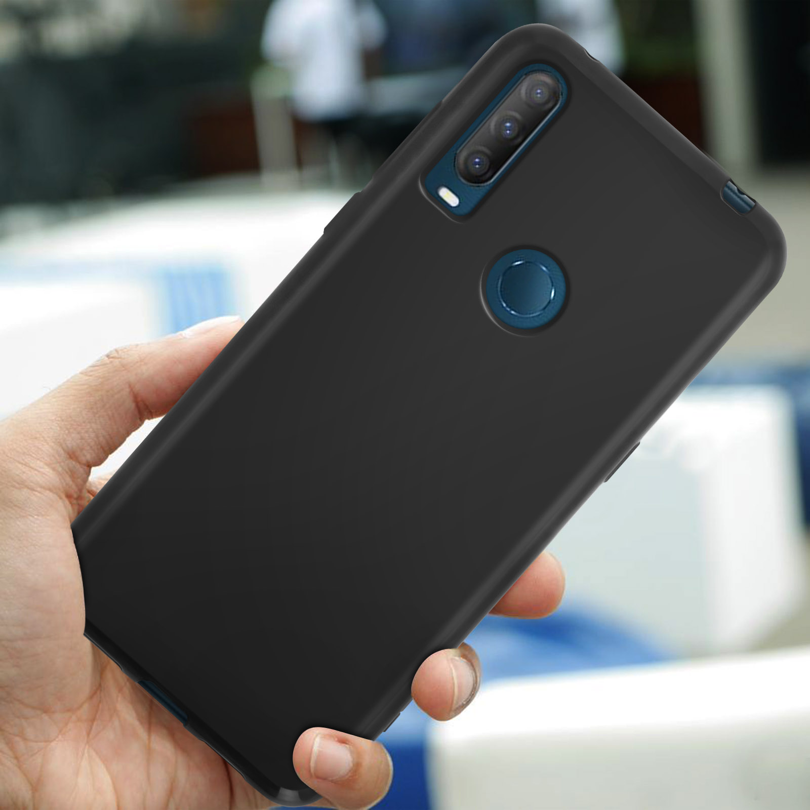 Une main tient une coque de téléphone noire avec triple caméra et capteur d'empreintes.