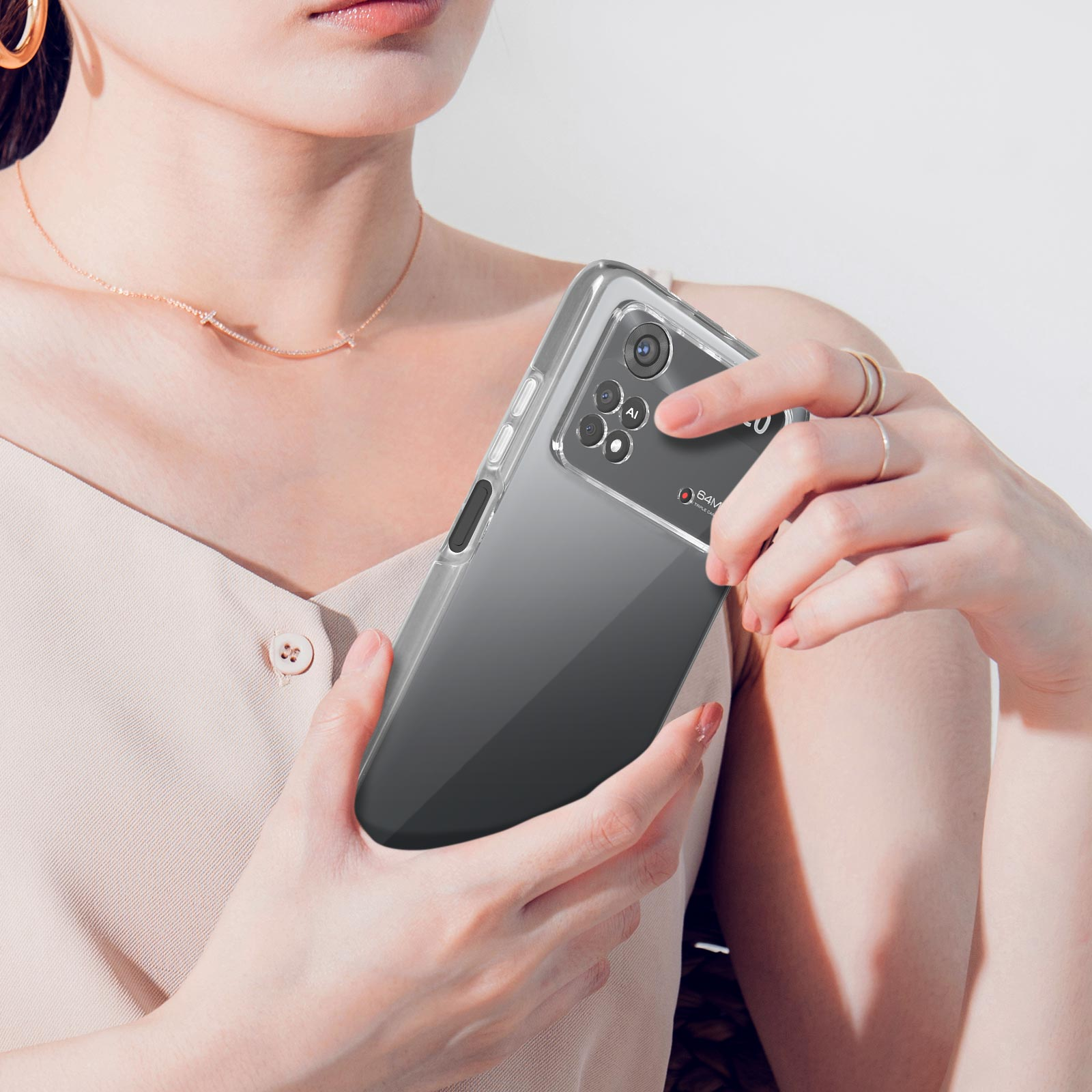 Une femme tient un smartphone dans un étui transparent. Gros plan sur le visage et les mains.
