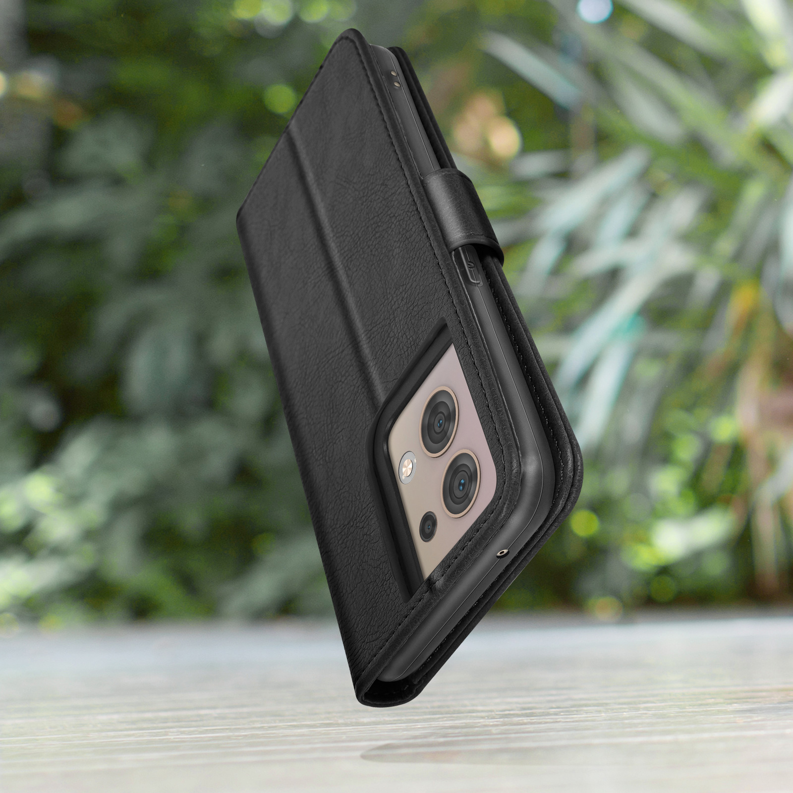 Zwarte leren flip telefoonhoes met camera-uitsparing, op hout.