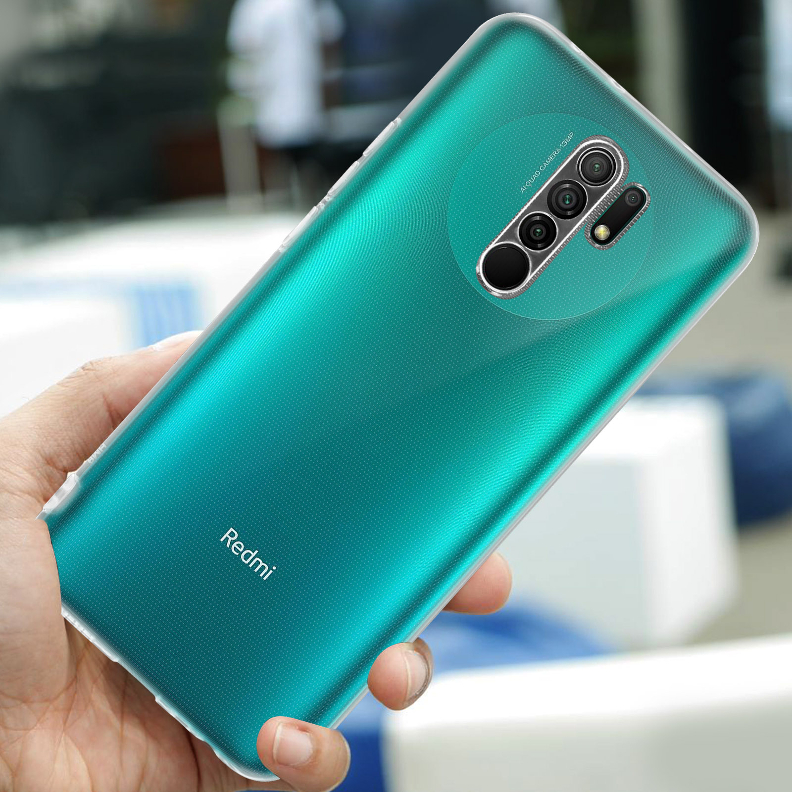 Een hand houdt een turquoise Redmi smartphone met vier camera's vast.
