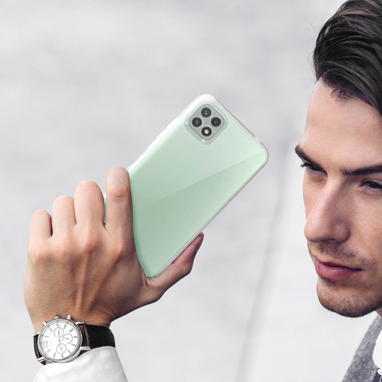 Un homme tenant un smartphone vert clair à quatre caméras. Gros plan.