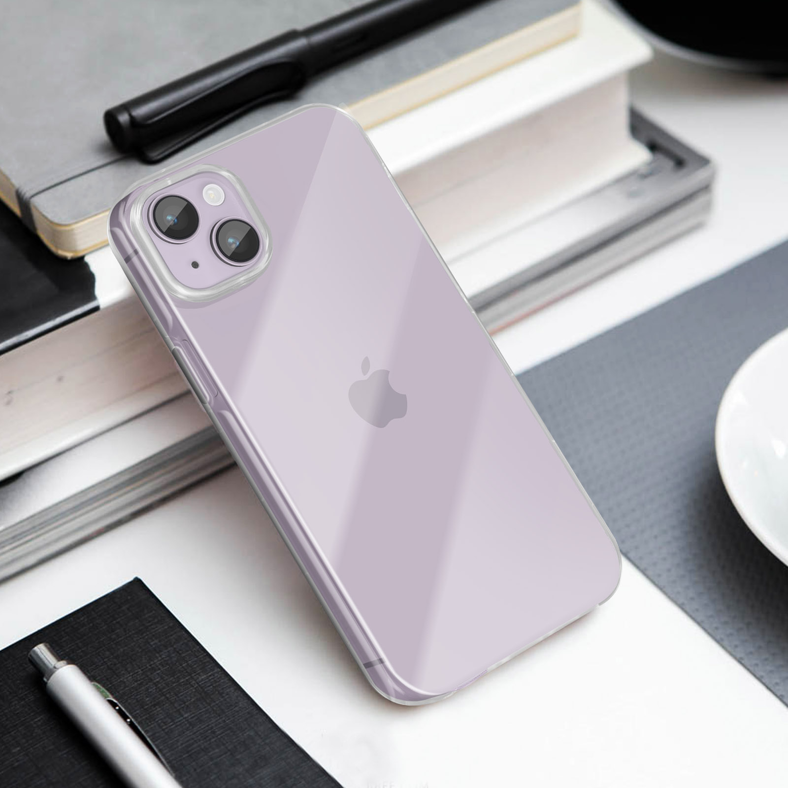 Un iPhone violet repose sur des livres et des carnets à côté d'un stylo.