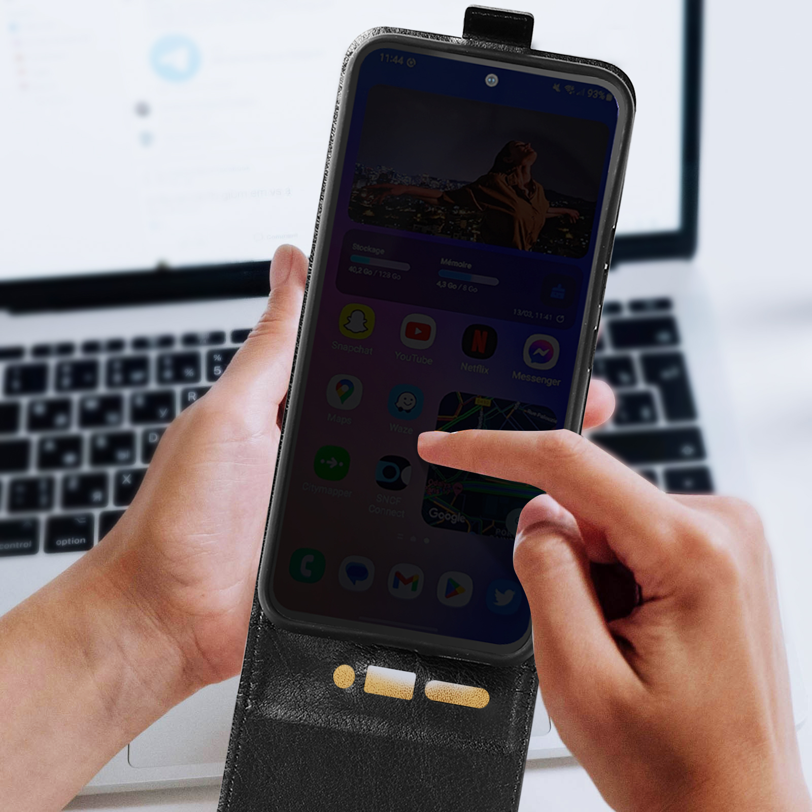 Een persoon houdt een smartphone vast met veel app-pictogrammen en een persoon op het scherm.