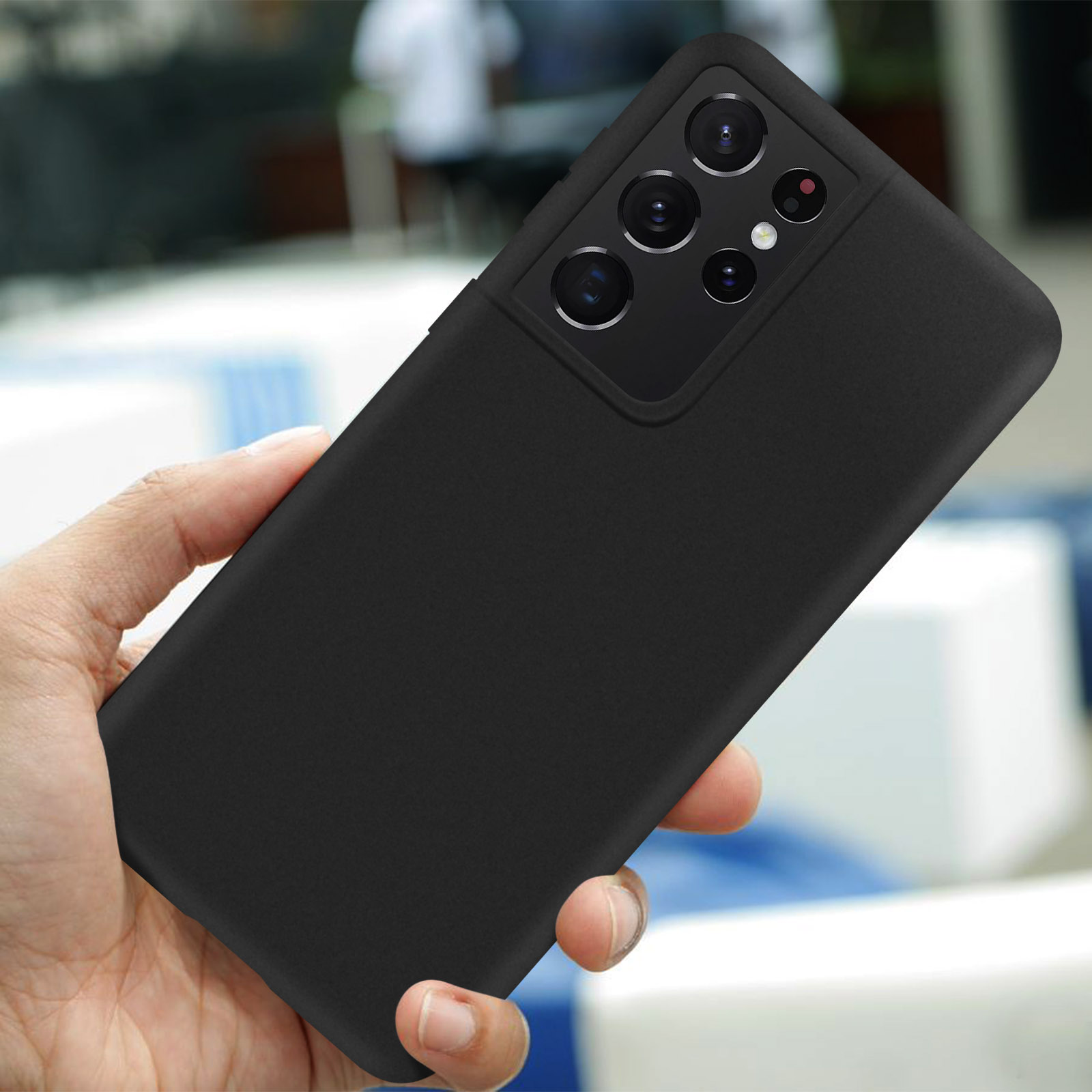 Une main tenant un téléphone portable noir avec une unité de caméra proéminente.