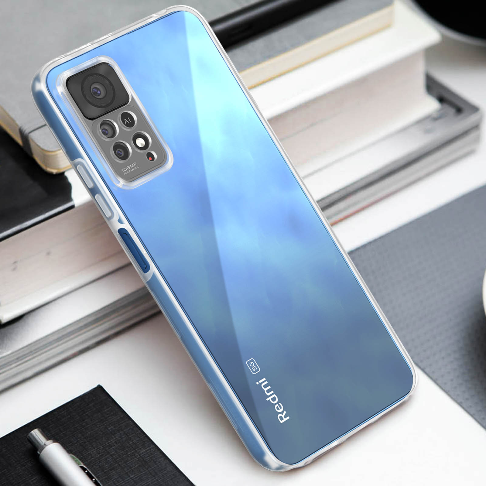 Een blauwe Redmi 5G telefoon in een doorzichtige hoes ligt op een bureau met notitieboekjes en een pen.