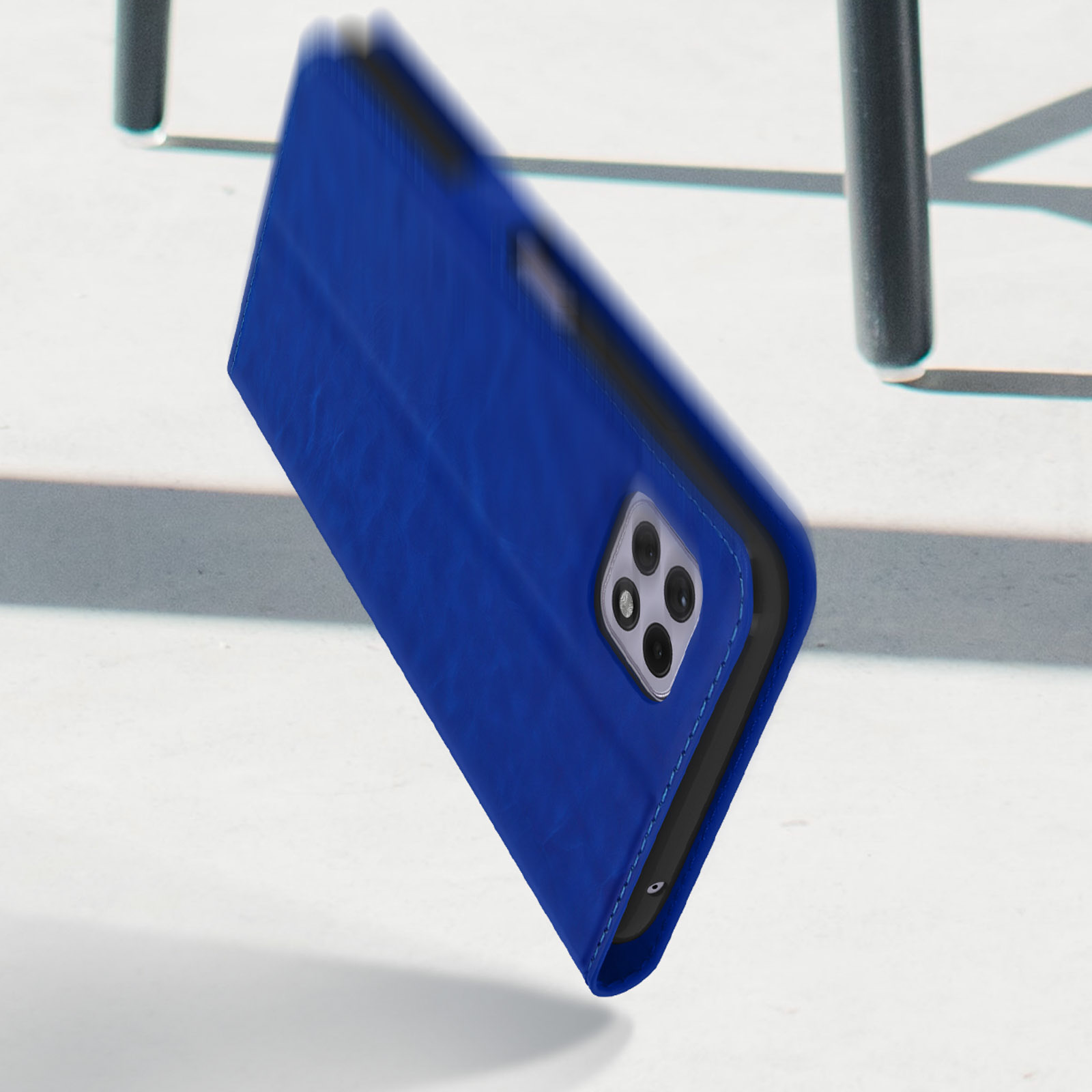 Étui de téléphone bleu avec ouverture pour appareil photo sur fond blanc avec ombres.
