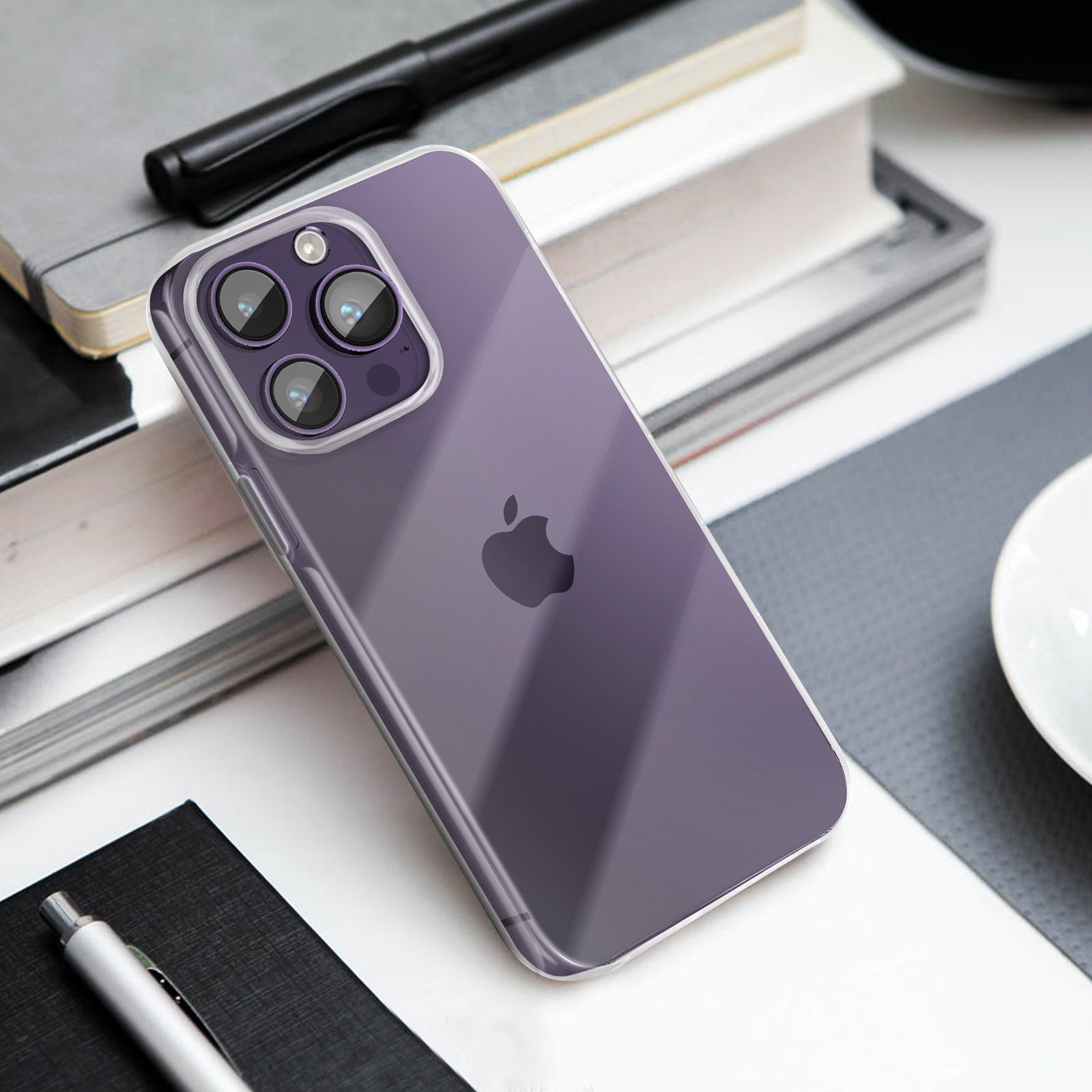 Una custodia viola per iPhone poggia su libri, penne e una tazza.