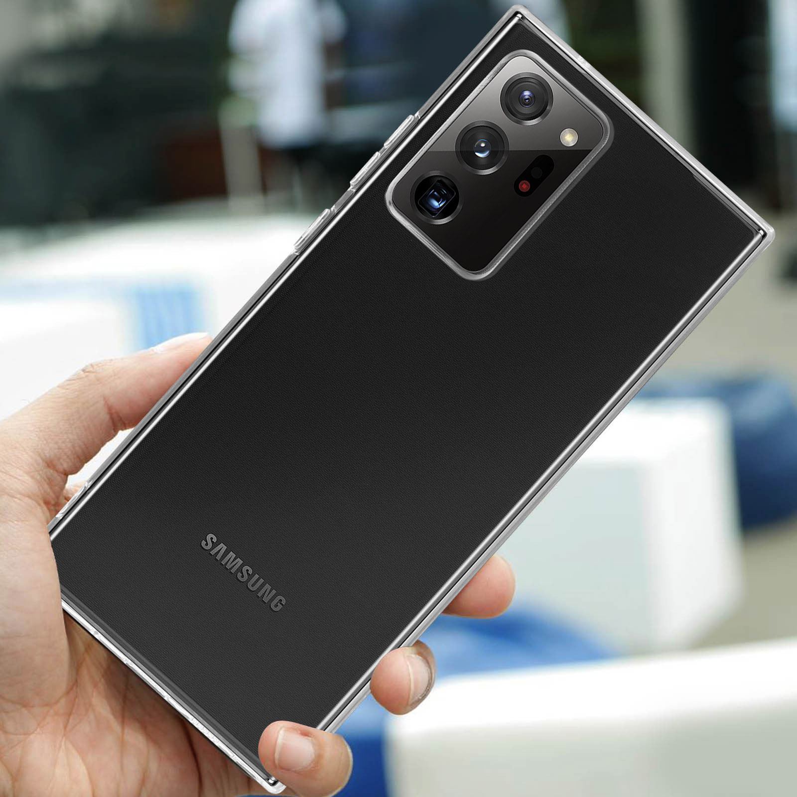 Een hand houdt een zwarte Samsung smartphone met zichtbare cameralens vast.
