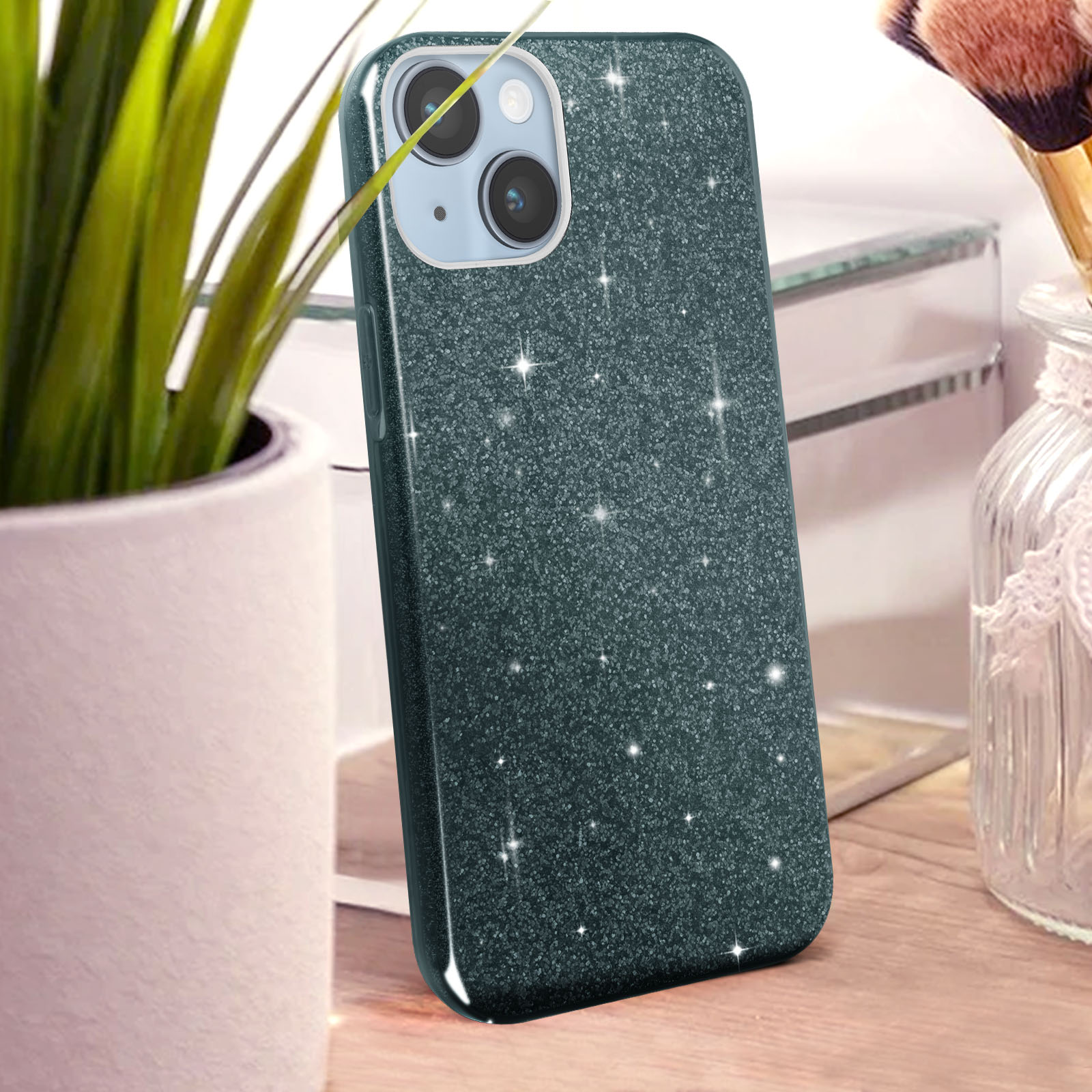 Custodia verde scuro glitterata per telefono su tavolo in legno.
