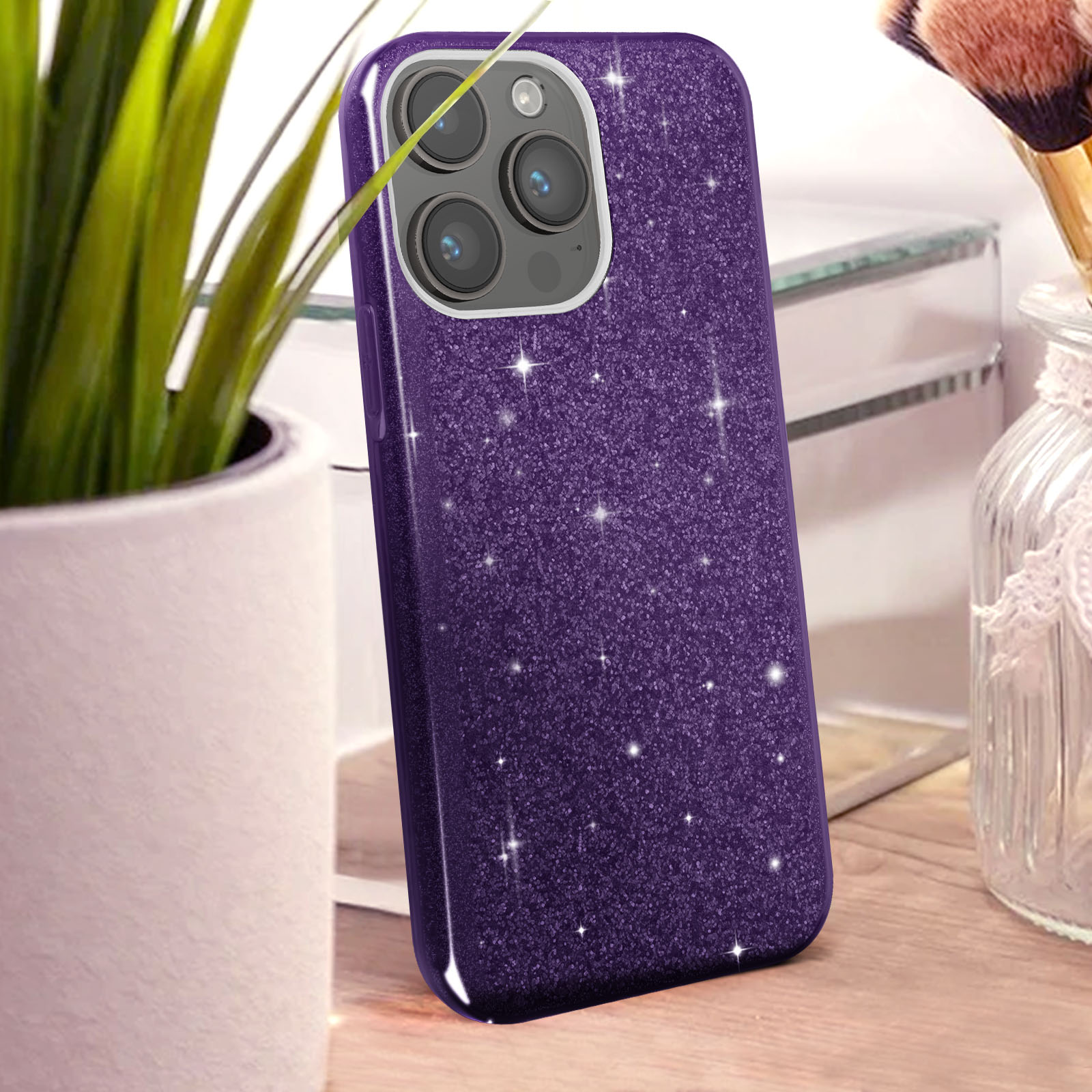 Custodia viola glitterata con tre fotocamere su tavolo legno.
