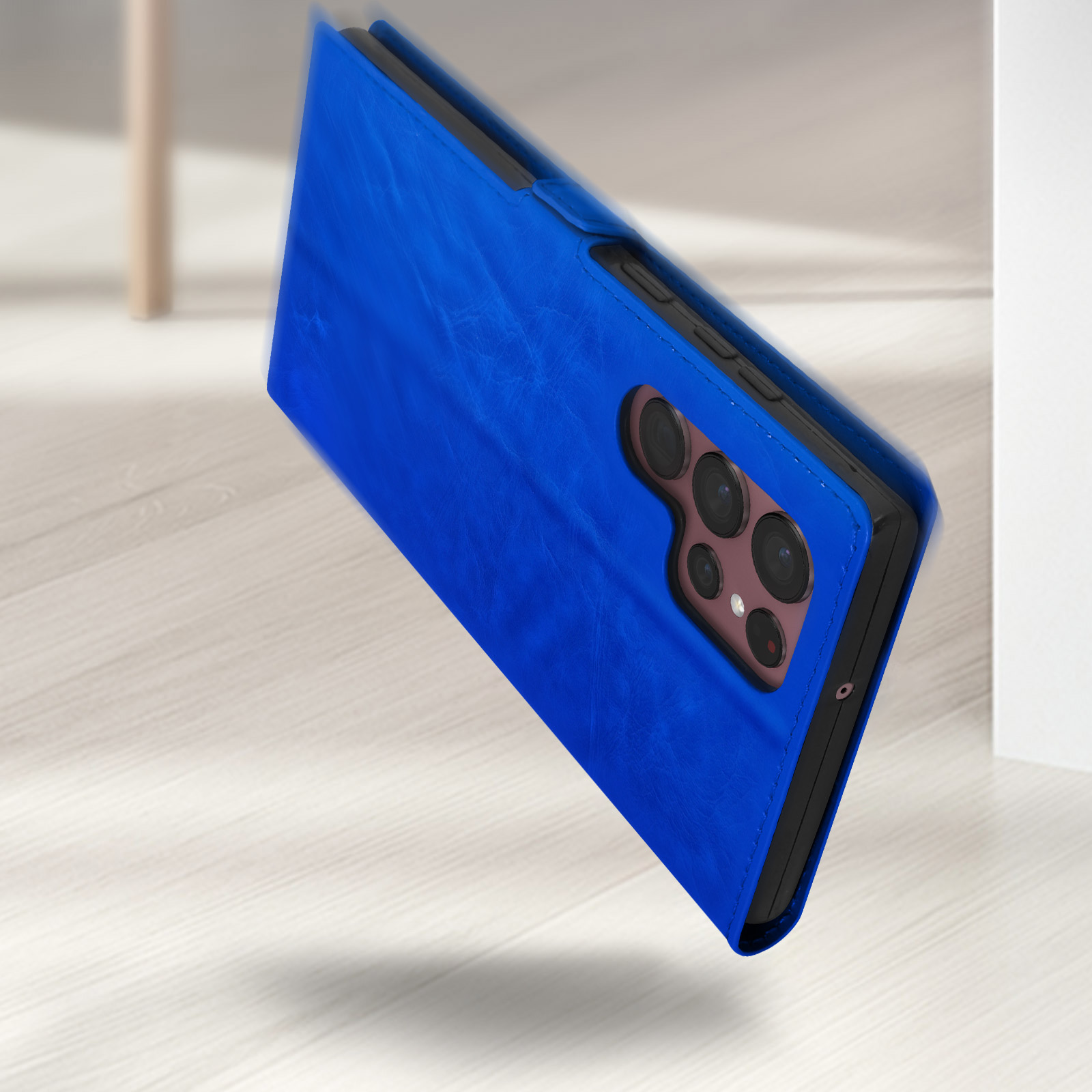 Un étui à rabat bleu pour téléphone repose sur un plancher en bois. La caméra est visible.