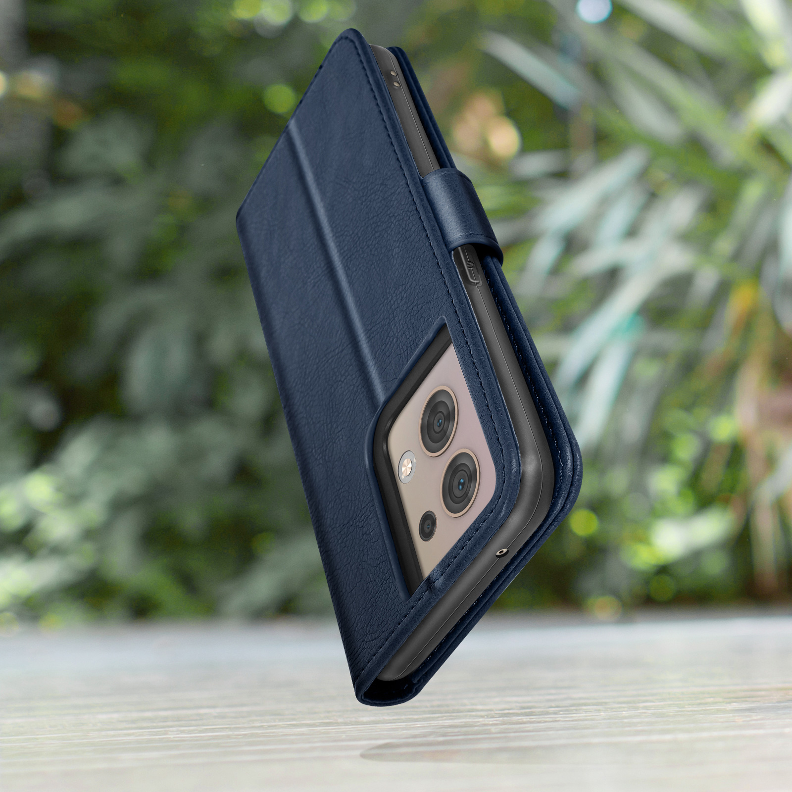 Étui de téléphone bleu foncé avec appareil photo et protection, en extérieur.