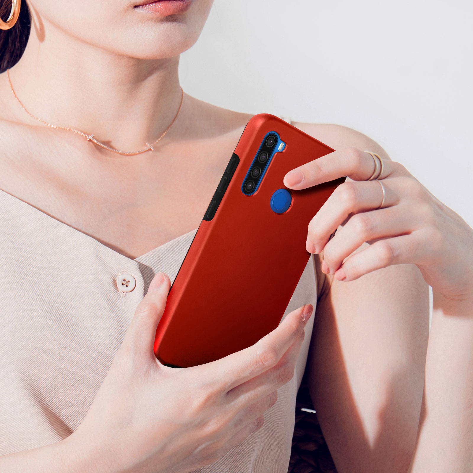Een vrouw houdt een rode smartphone met vier camera's en een blauwe vingerafdruksensor vast.