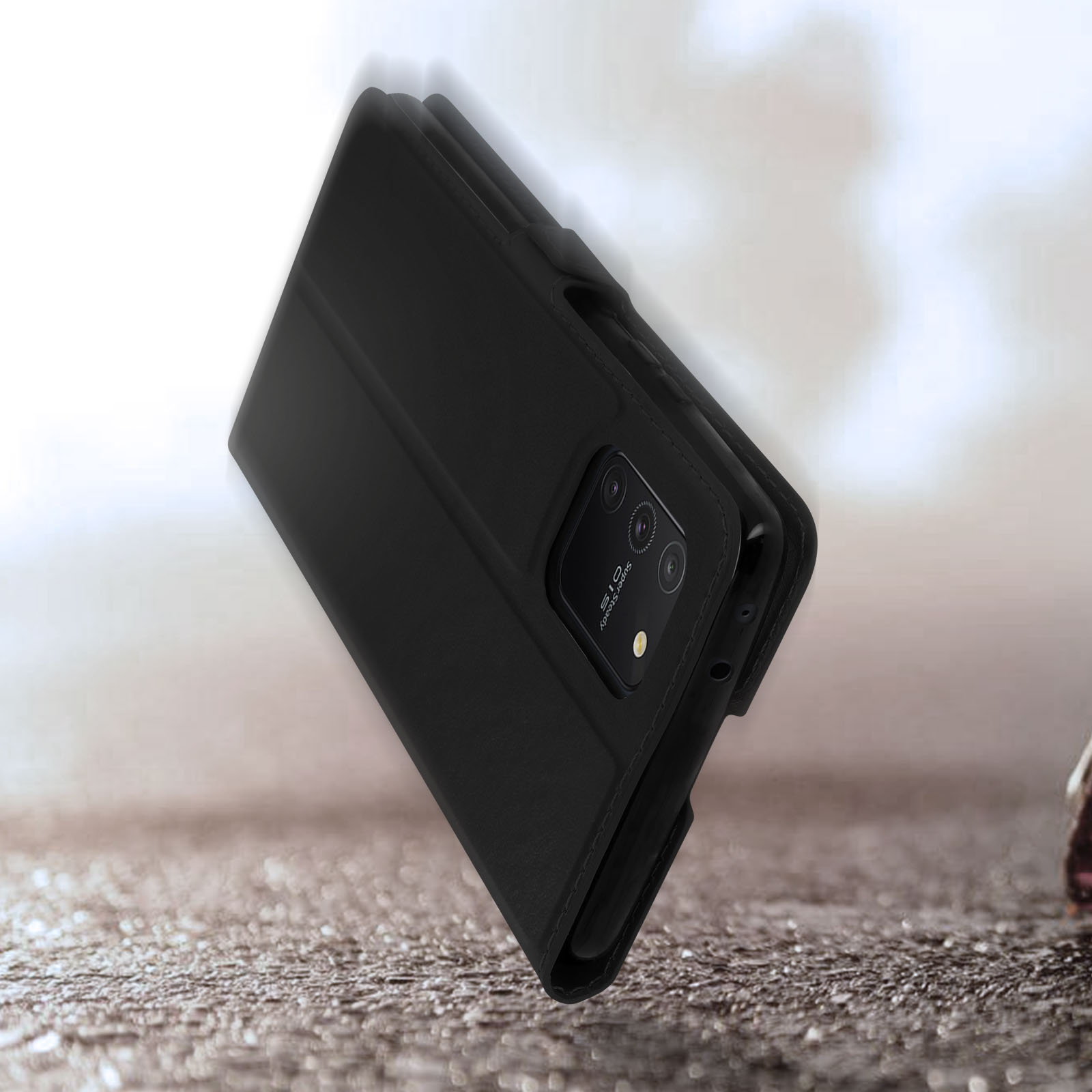 Étui noir à rabat pour téléphone sur une surface pierreuse.