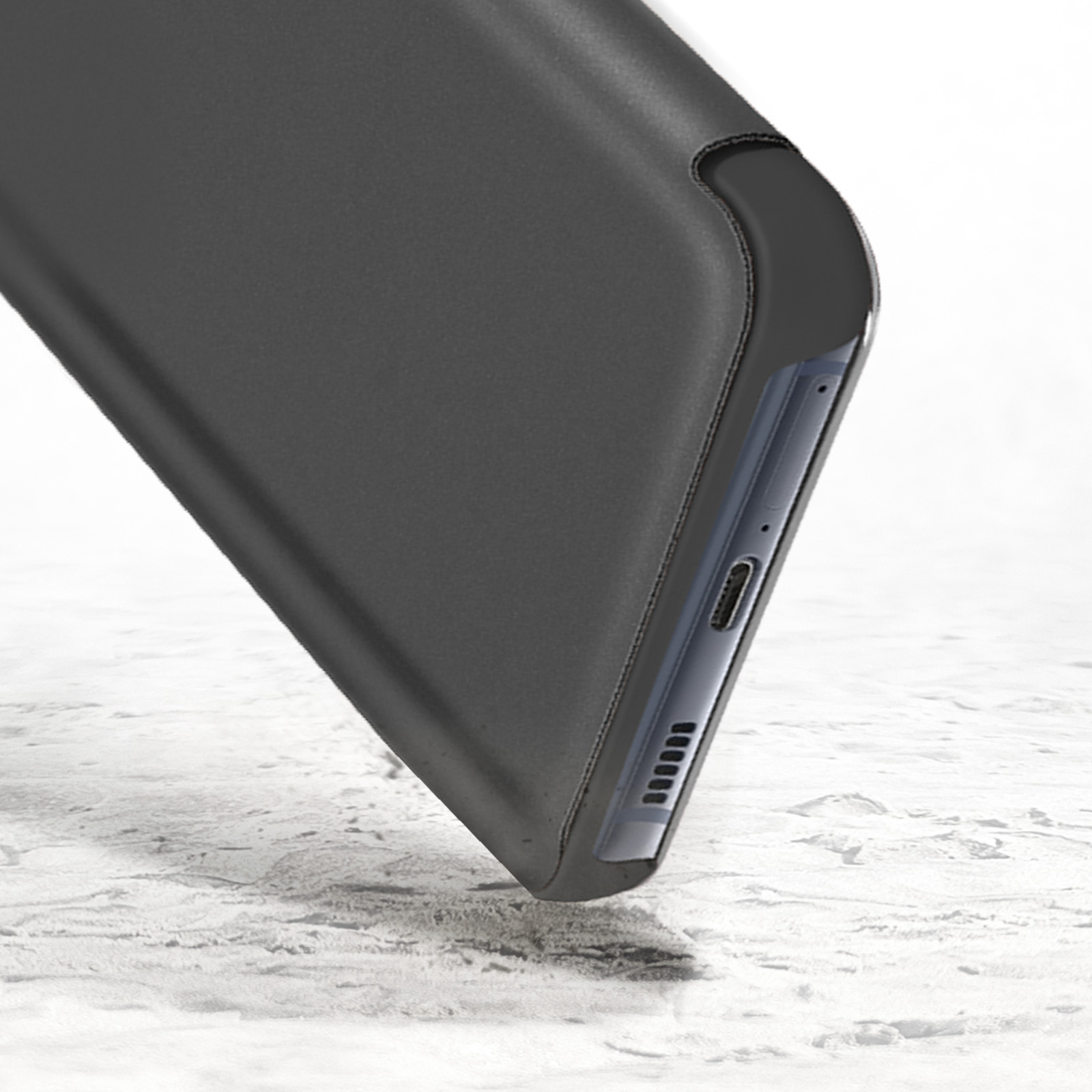 Smartphone nero in custodia appoggiato su una superficie testurizzata.
