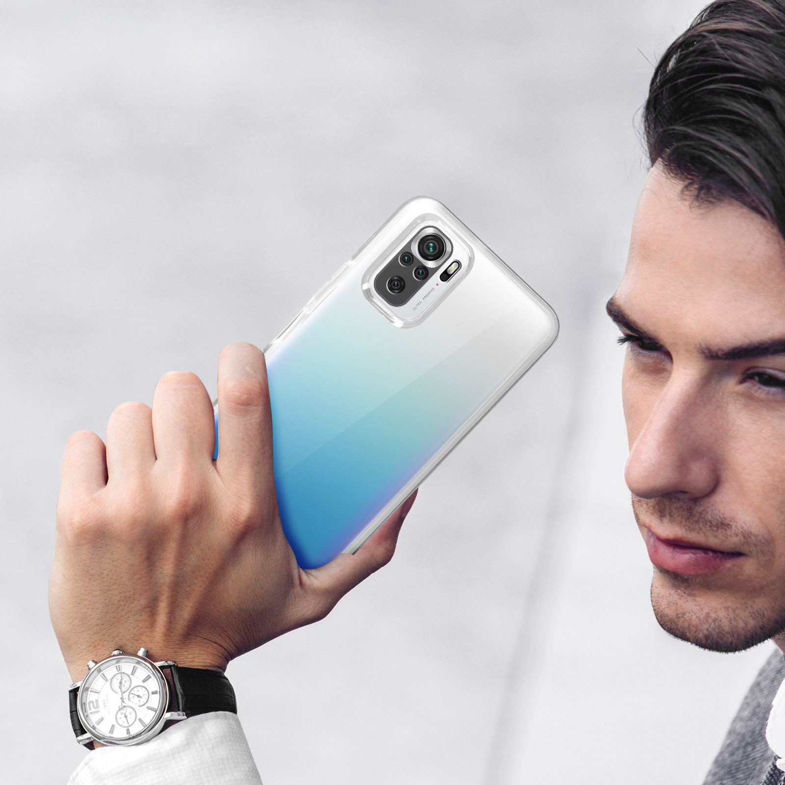 Uomo con orologio tiene uno smartphone con quattro fotocamere.