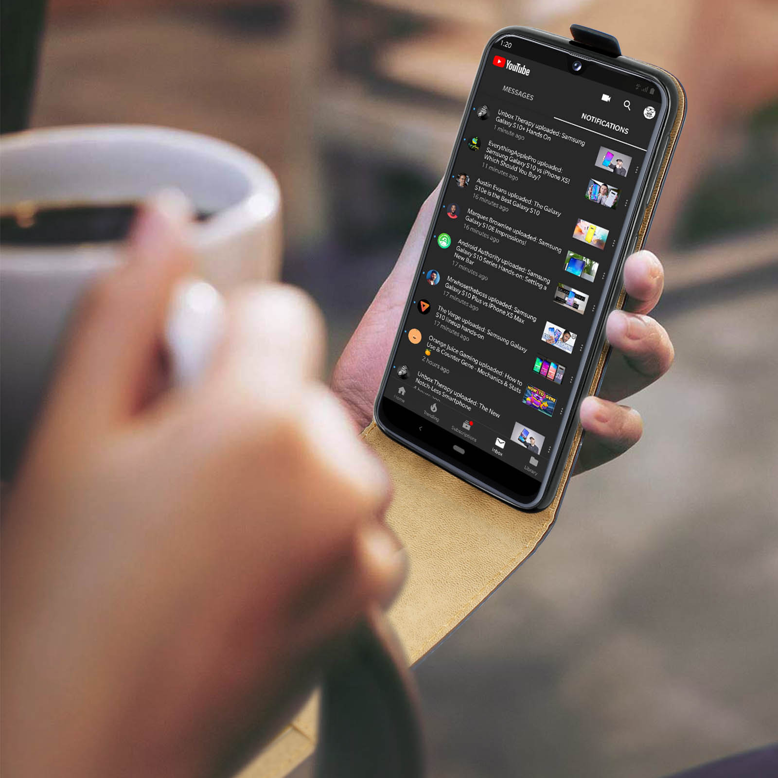 Una mano tiene uno smartphone con l'app YouTube e notifiche.