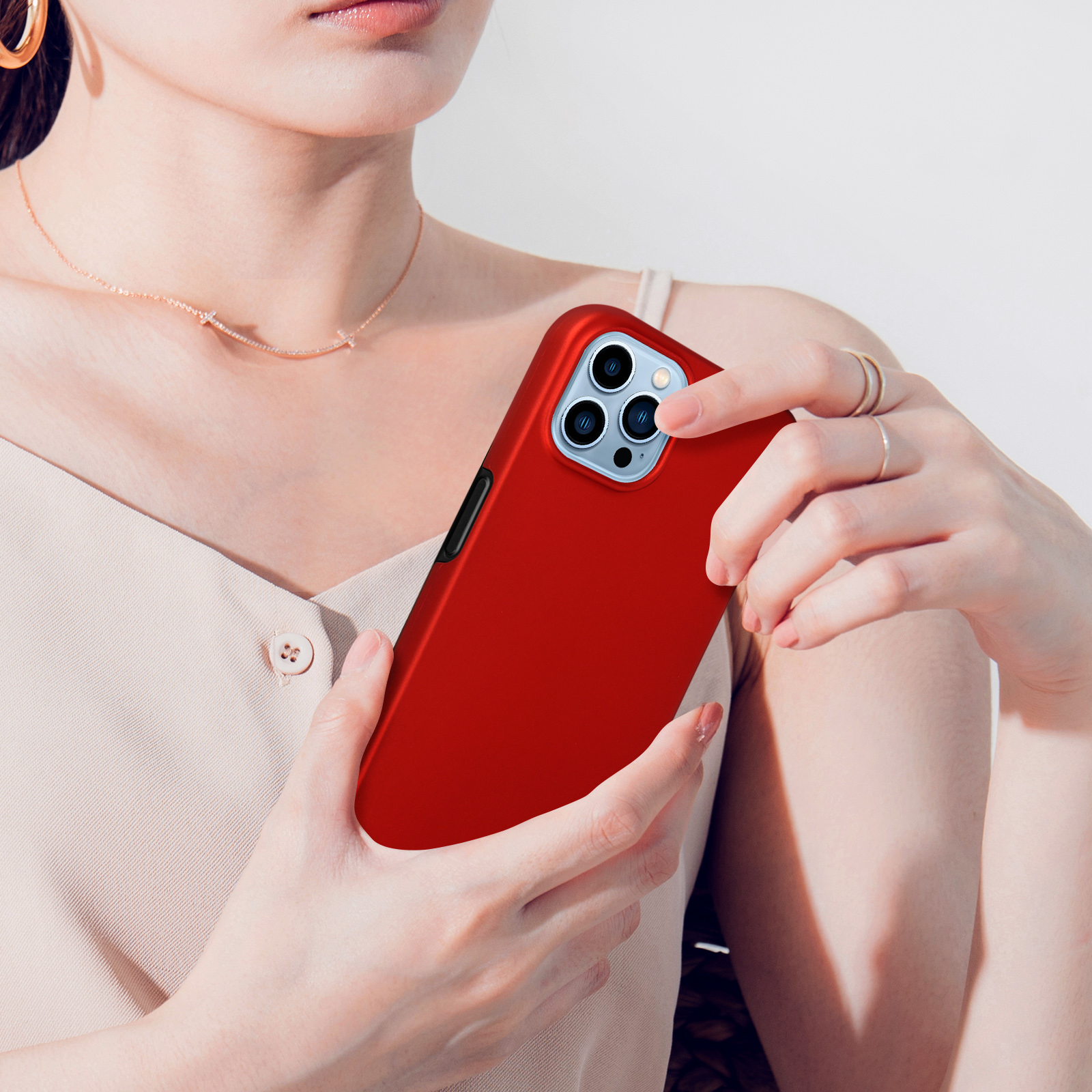 Una donna tiene un telefono rosso con tre fotocamere.