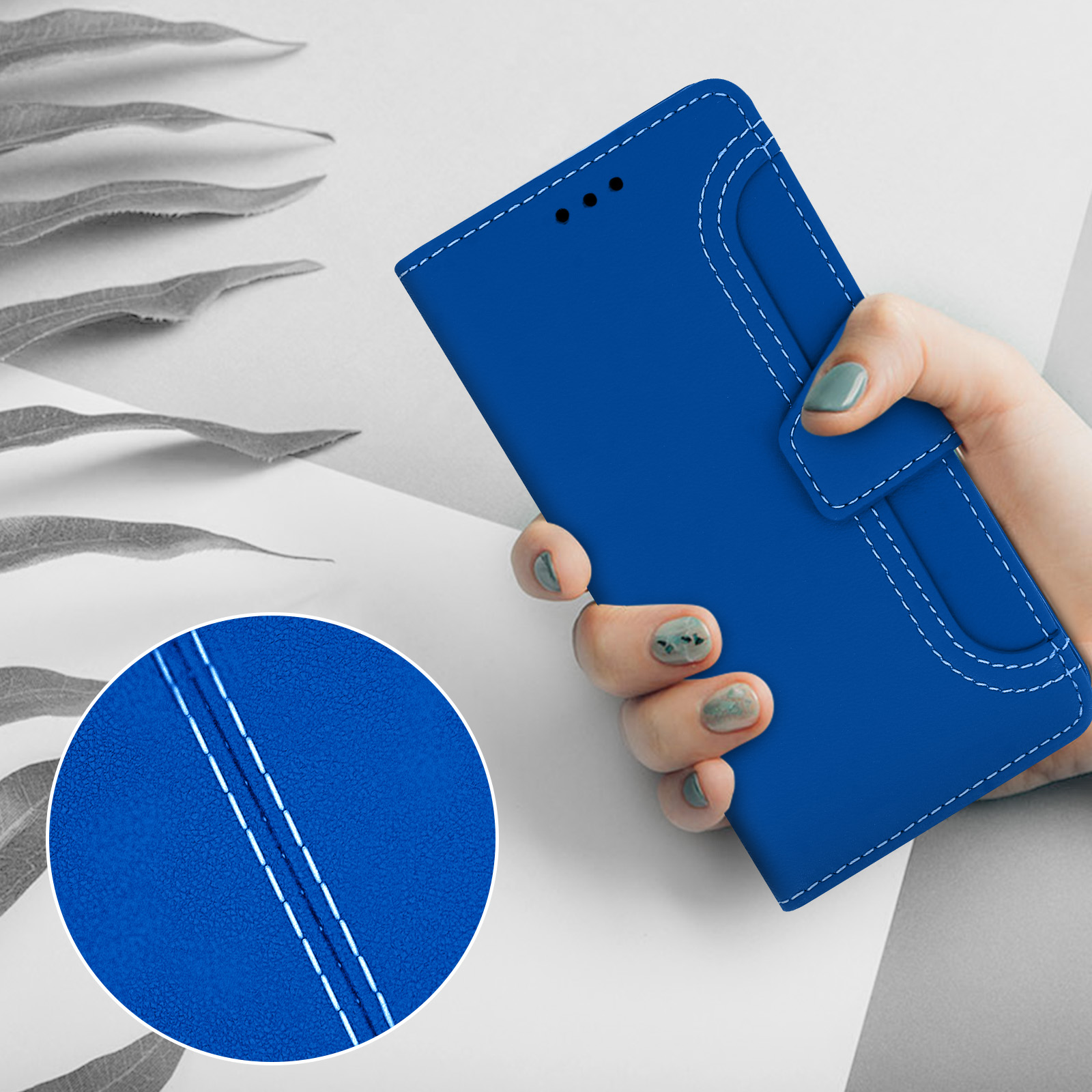 Een hand houdt een blauwe telefoonhoes vast met witte stiksels. Close-up toont textuur.