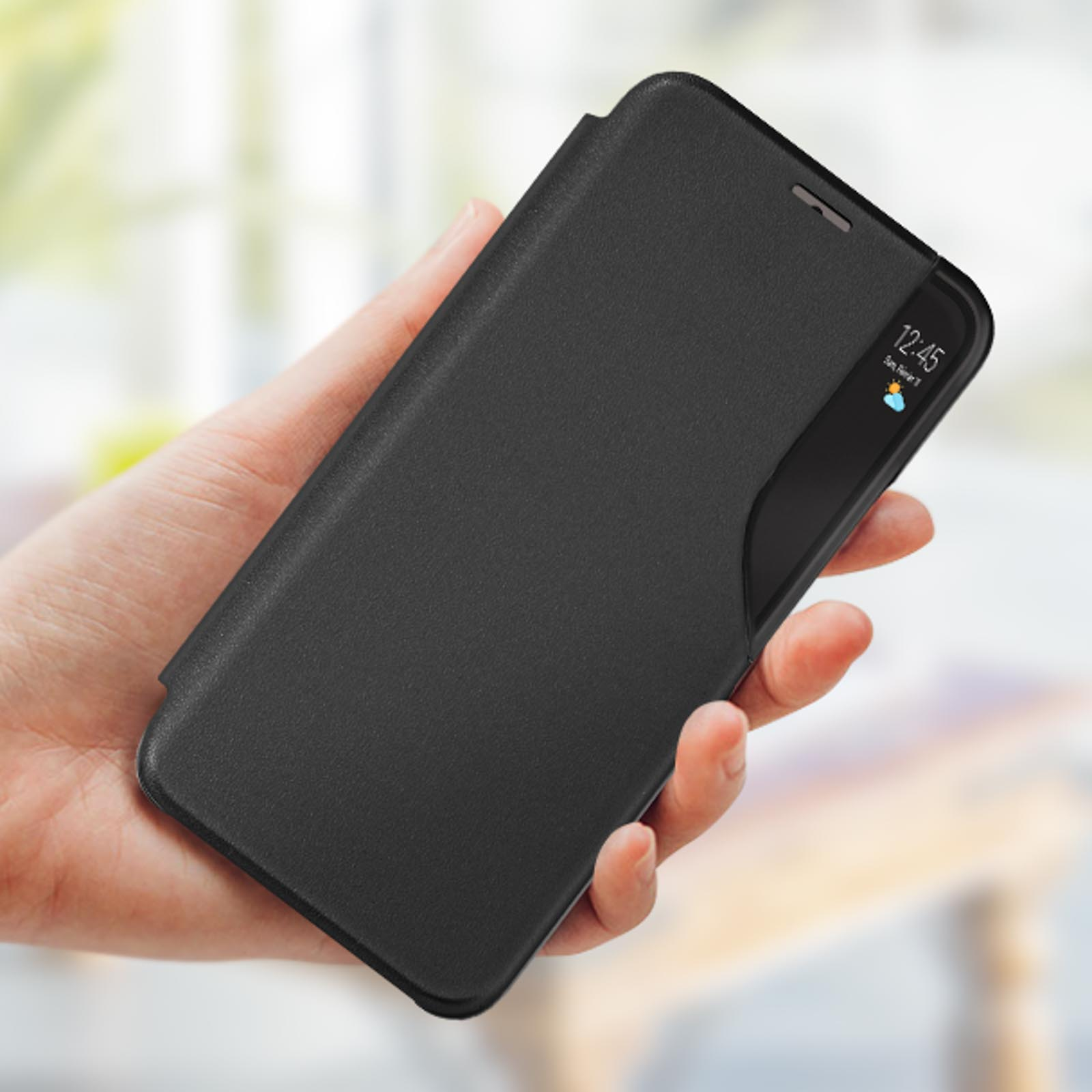 Eine Hand hält ein schwarzes Handy mit einer Klapphülle, die die Uhrzeit anzeigt.