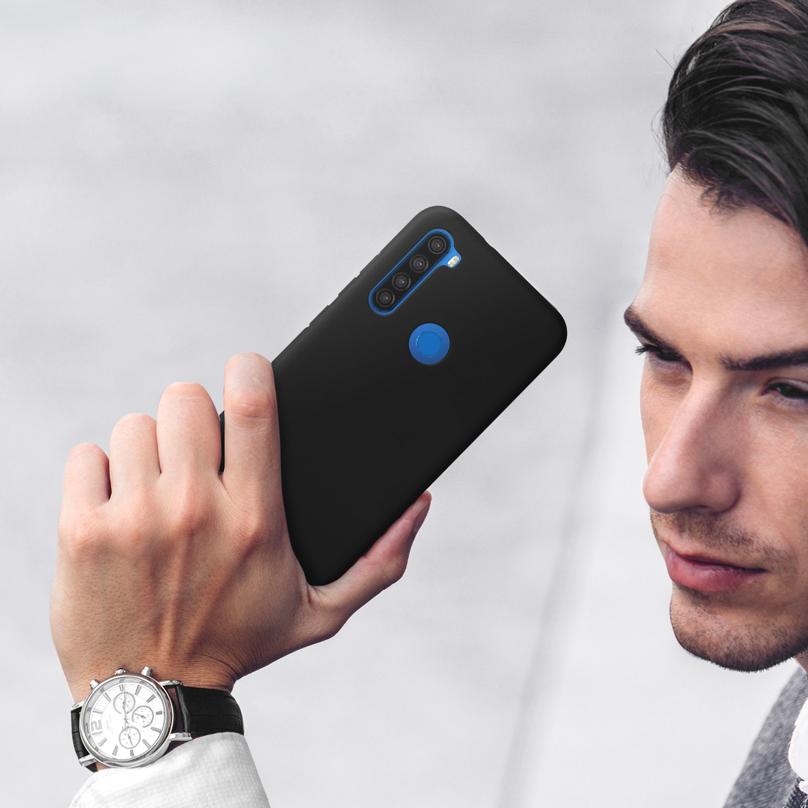 Man houdt een zwarte smartphone vast met vier camera's en een blauwe cirkel.