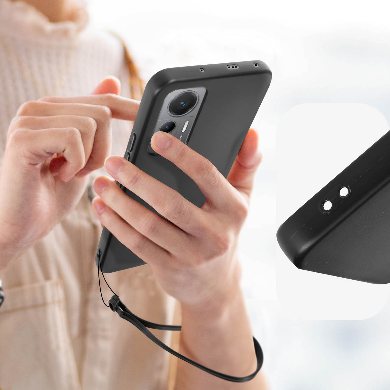 Een persoon houdt een zwarte smartphone vast met hoesje en koord.