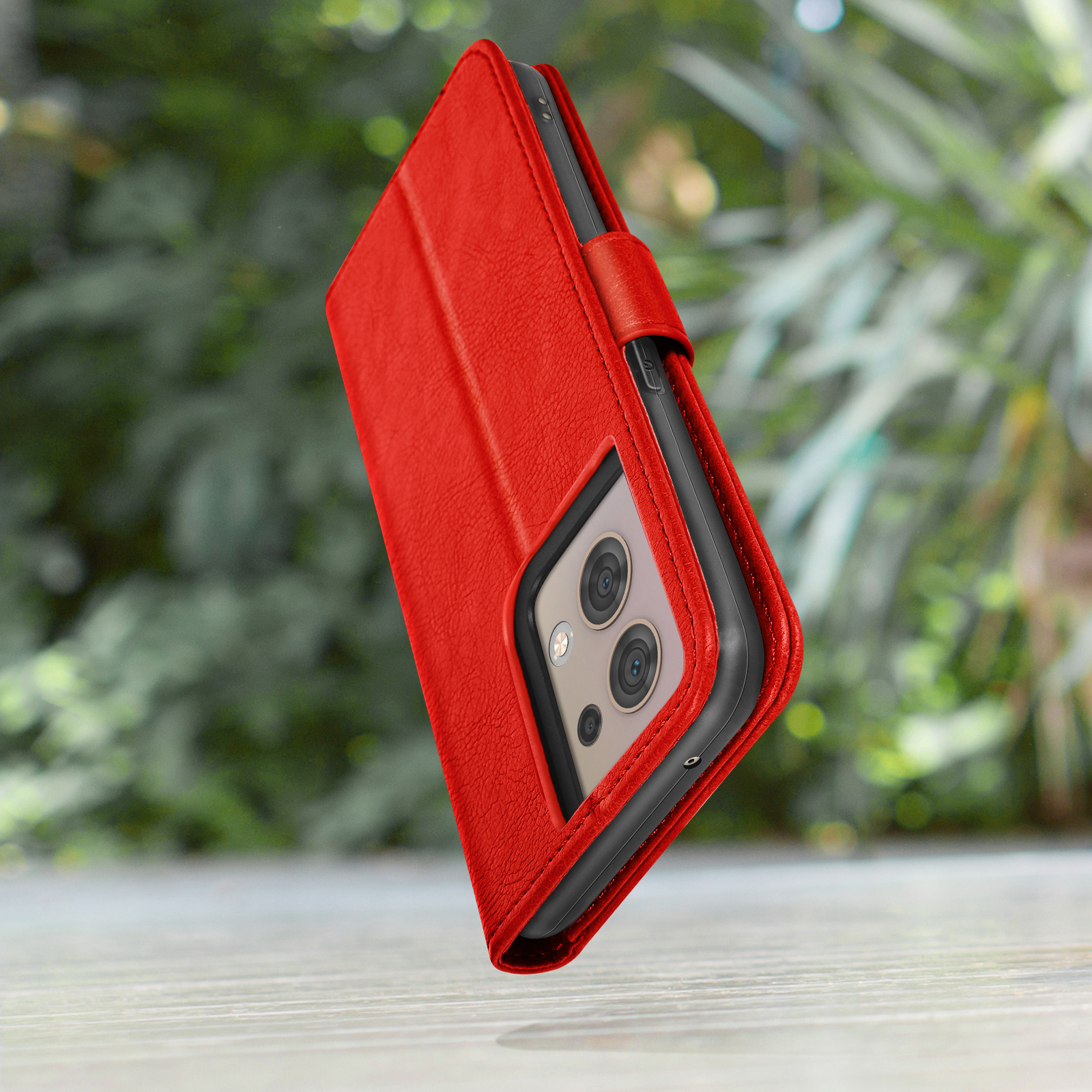 Rode telefoonhoes met camera-opening, zwevend voor groene achtergrond.