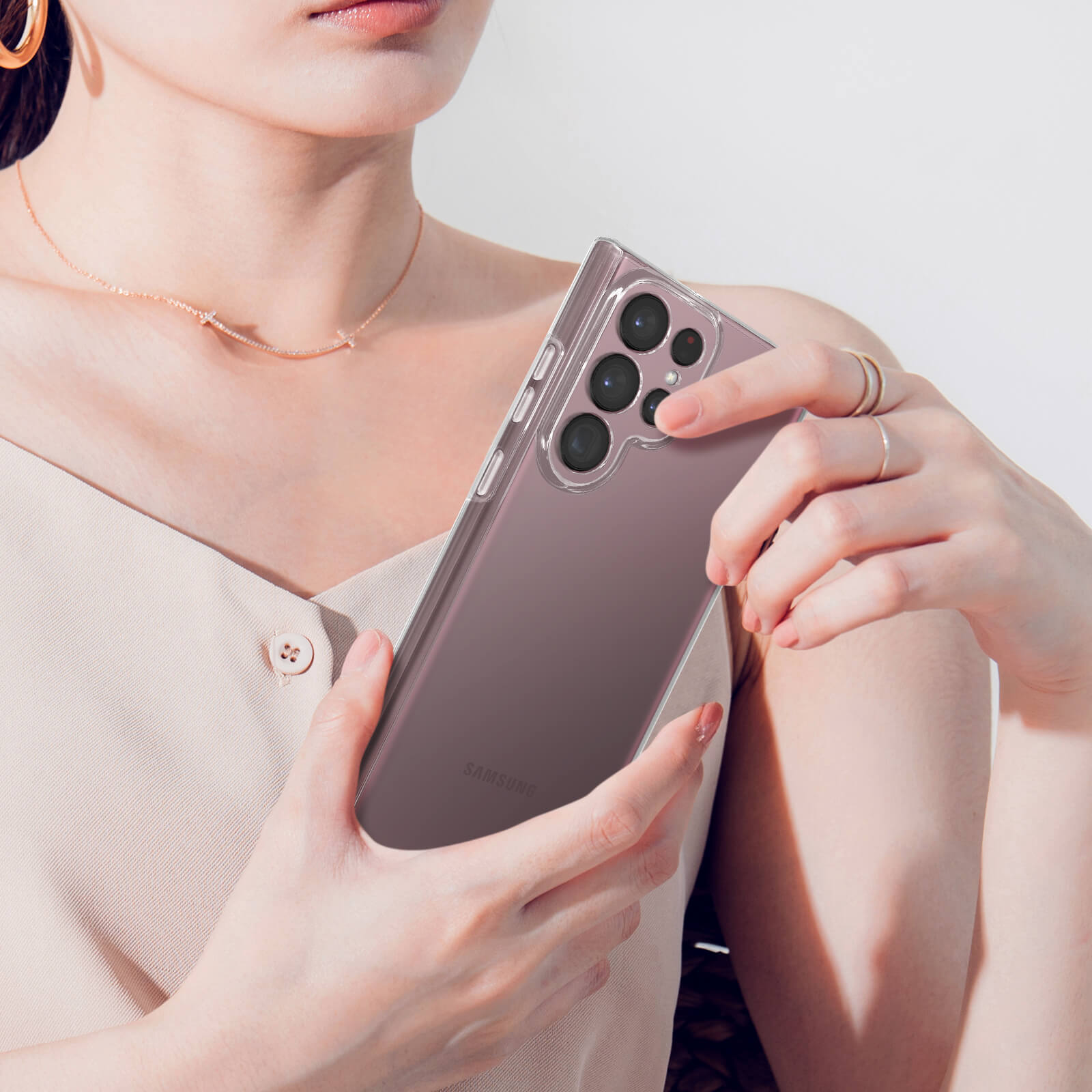 Une femme tient un téléphone transparent à quatre caméras.