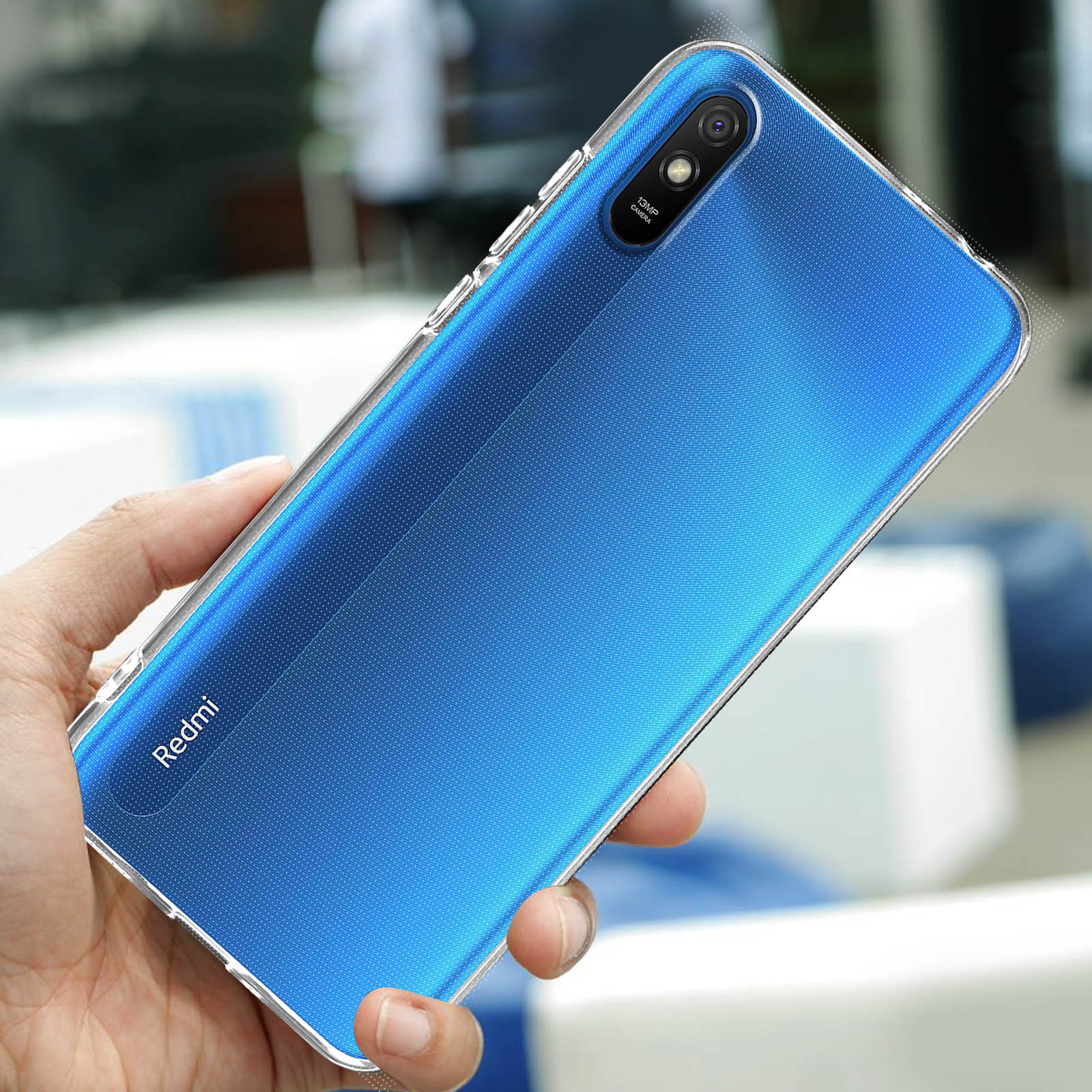 Een hand houdt een blauwe telefoon vast in een doorzichtige hoes, met camera en 'Redmi'-logo.