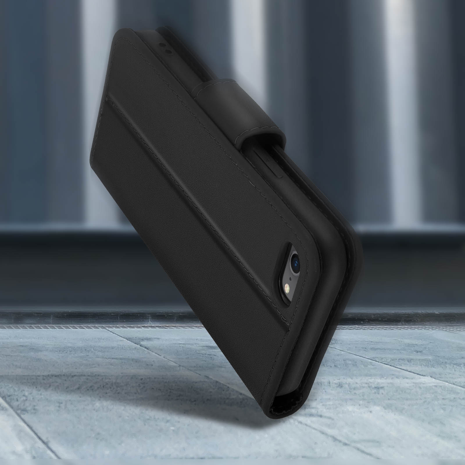 Zwarte lederen flip telefoonhoes met stiksels, op een stenen ondergrond.